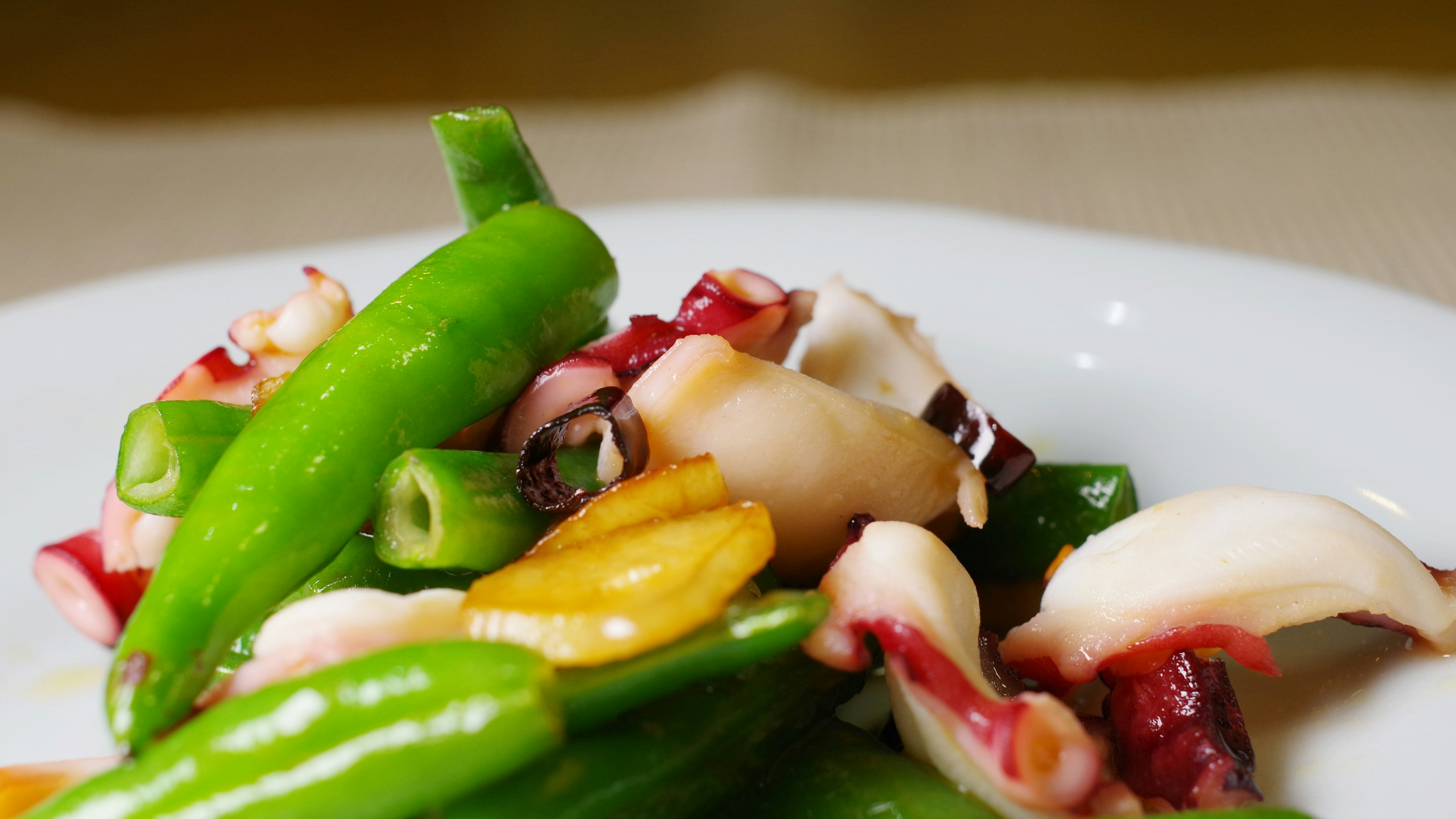 Close-up of a salad featuring green vegetables and octopus