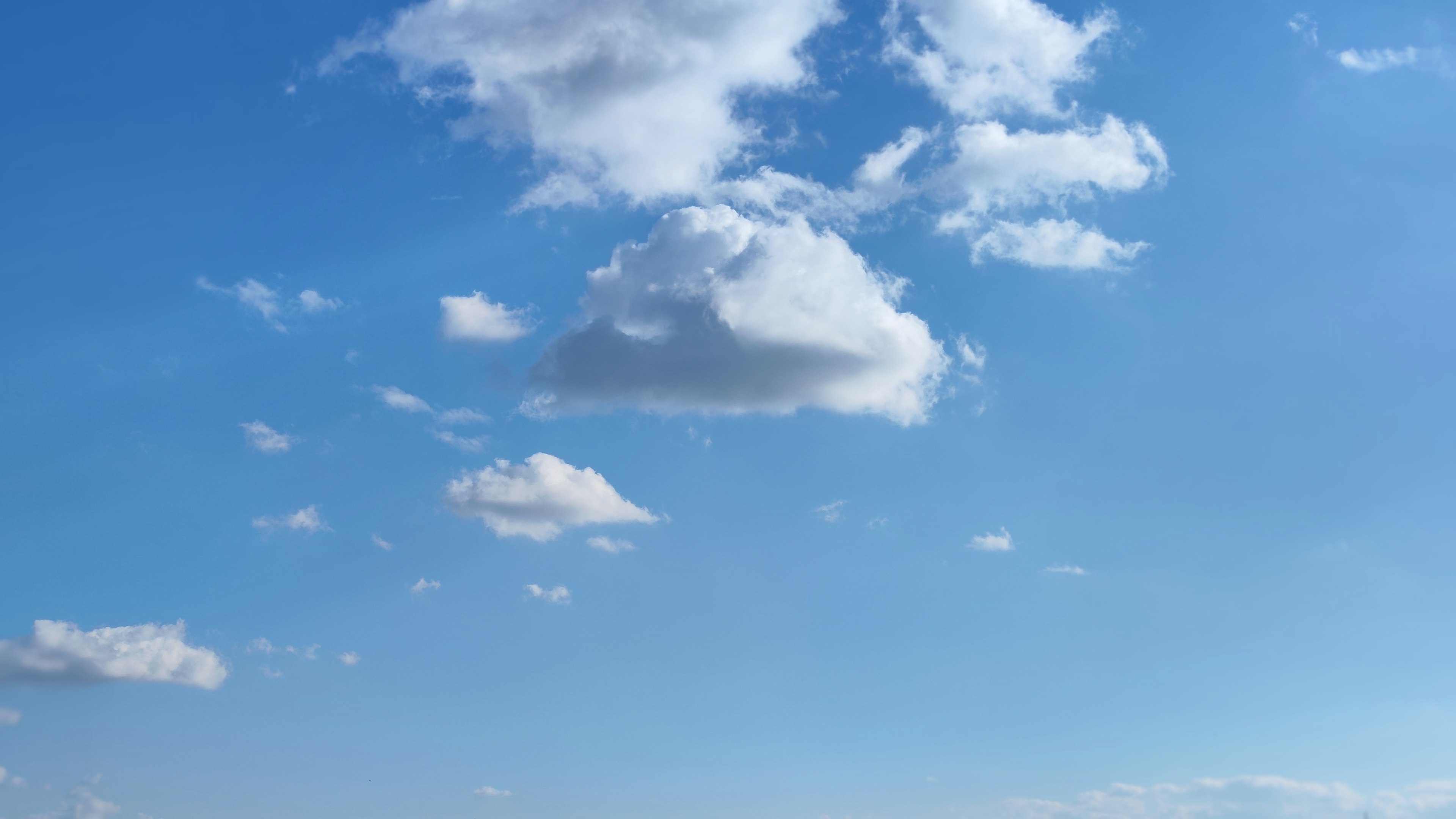 Eine Landschaft mit weißen Wolken, die in einem blauen Himmel schweben