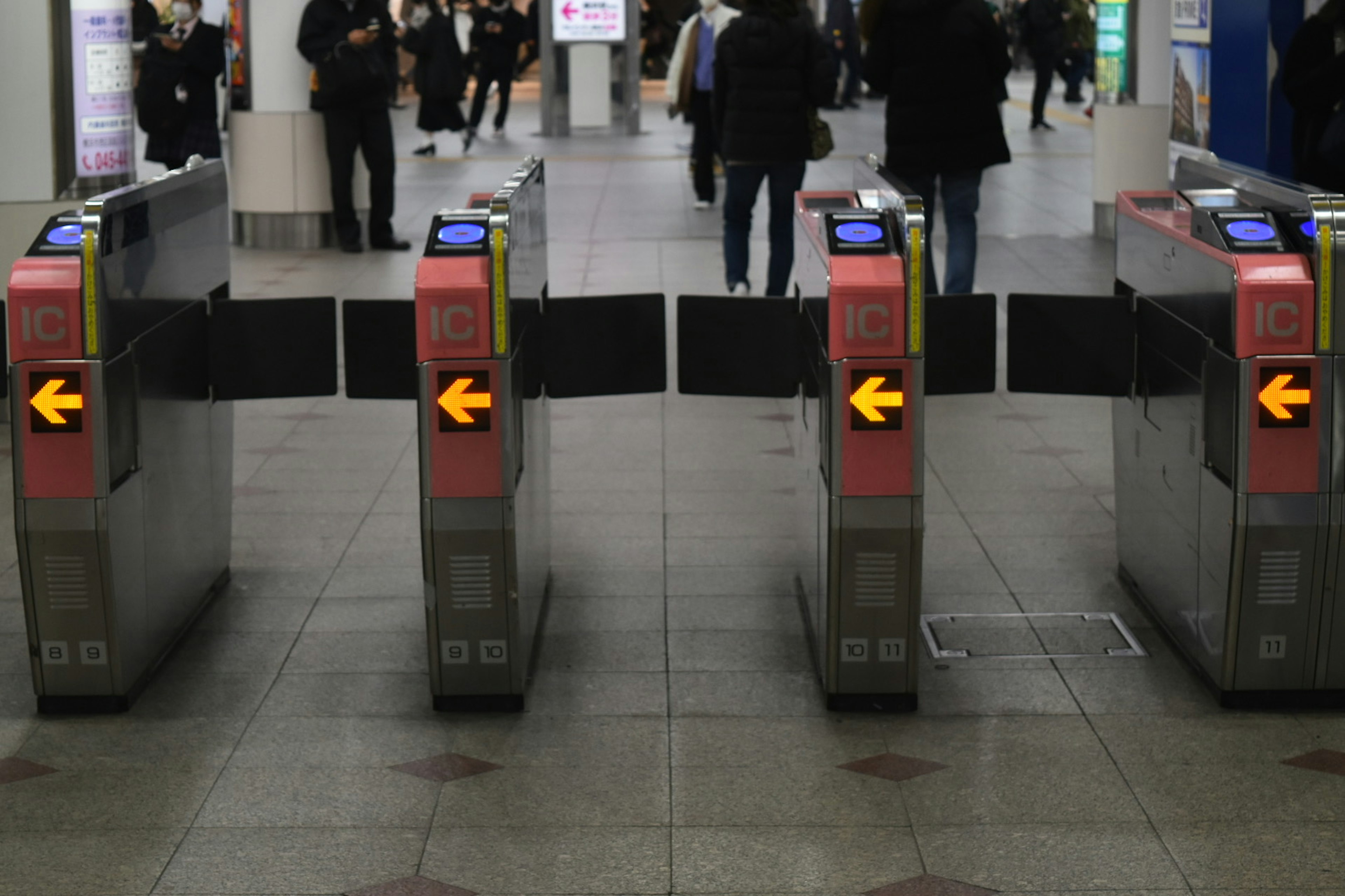 View of ticket gates at a train station with people passing through