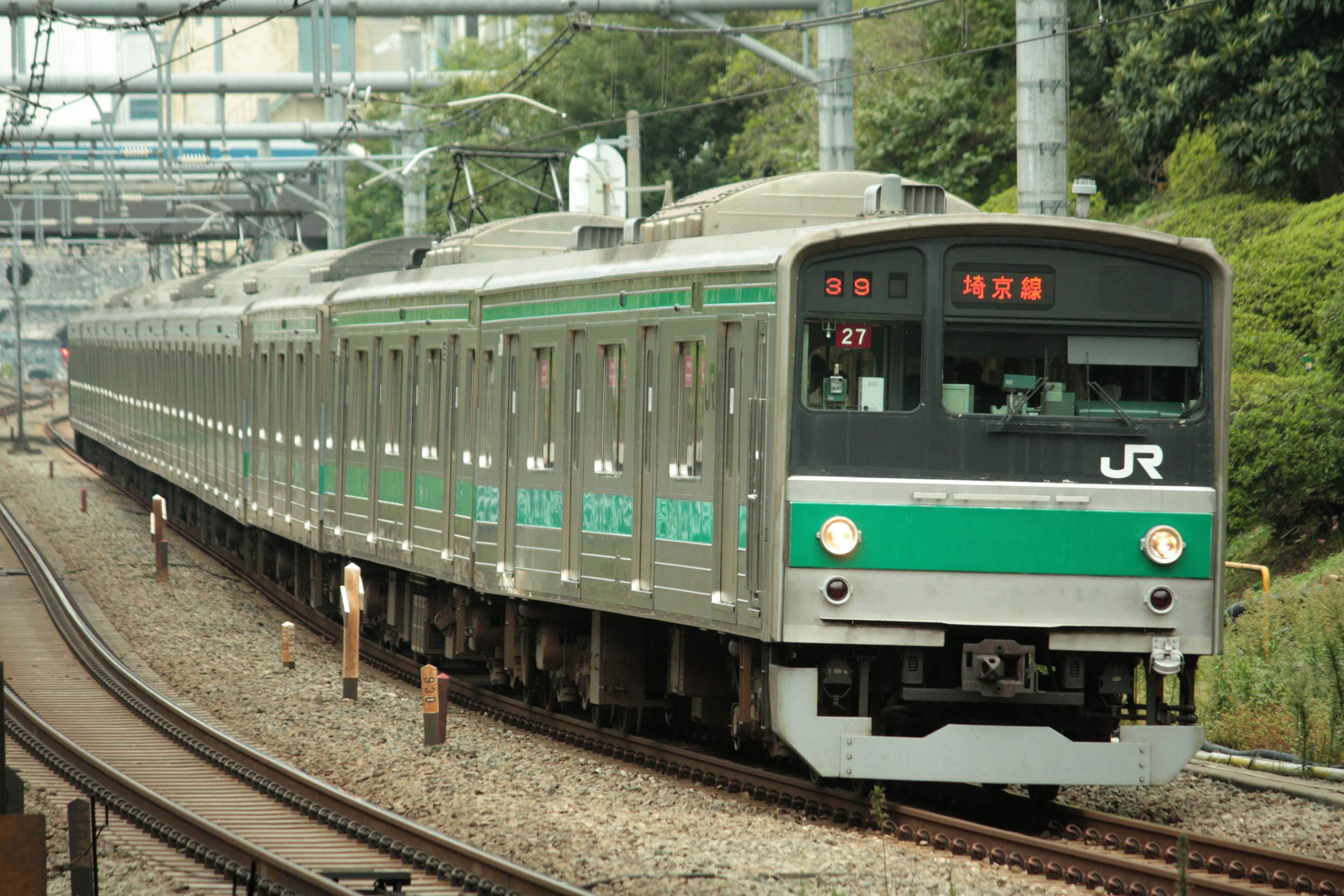 Tren JR con rayas verdes circulando por las vías