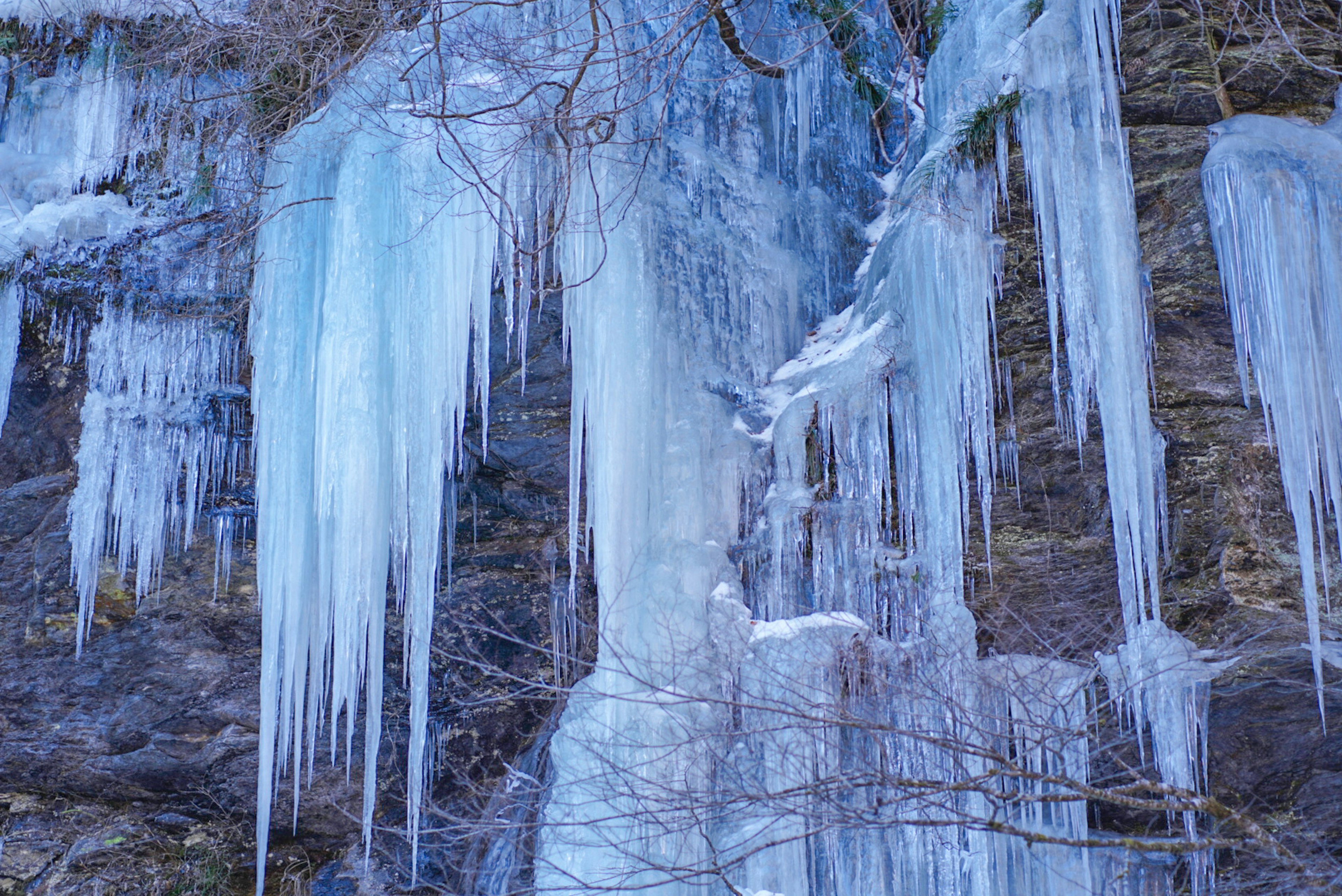 Gocce di ghiaccio appese a una superficie rocciosa in inverno