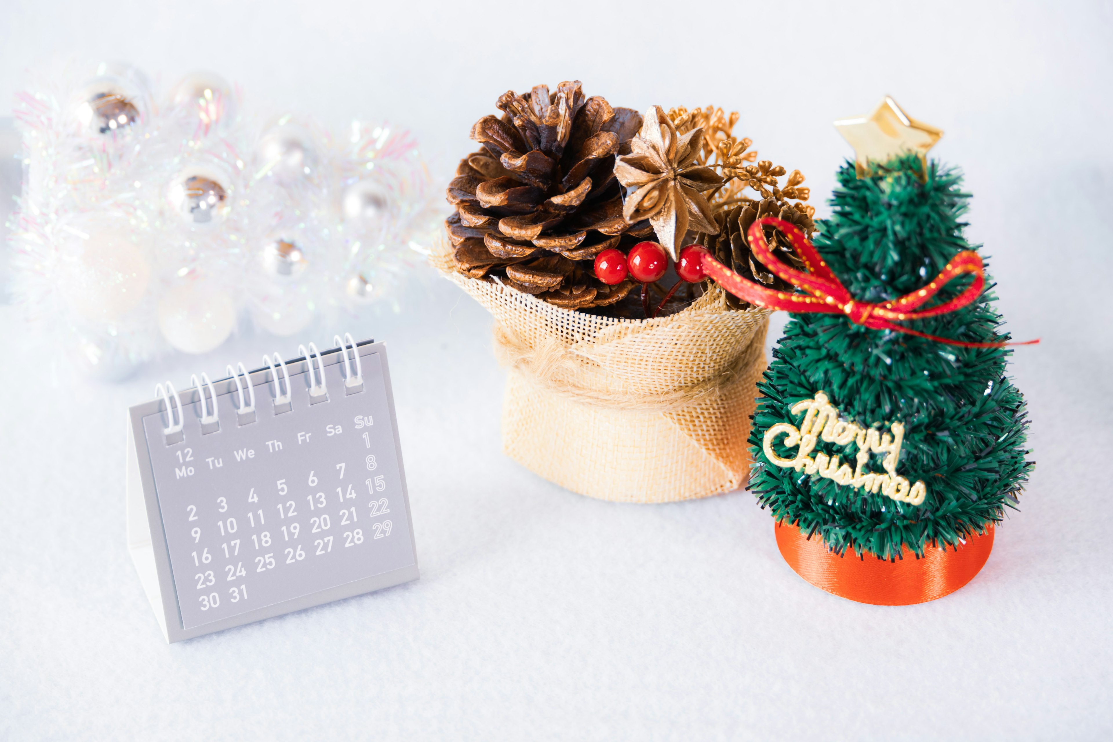 Escena decorativa con un árbol de Navidad y piñas