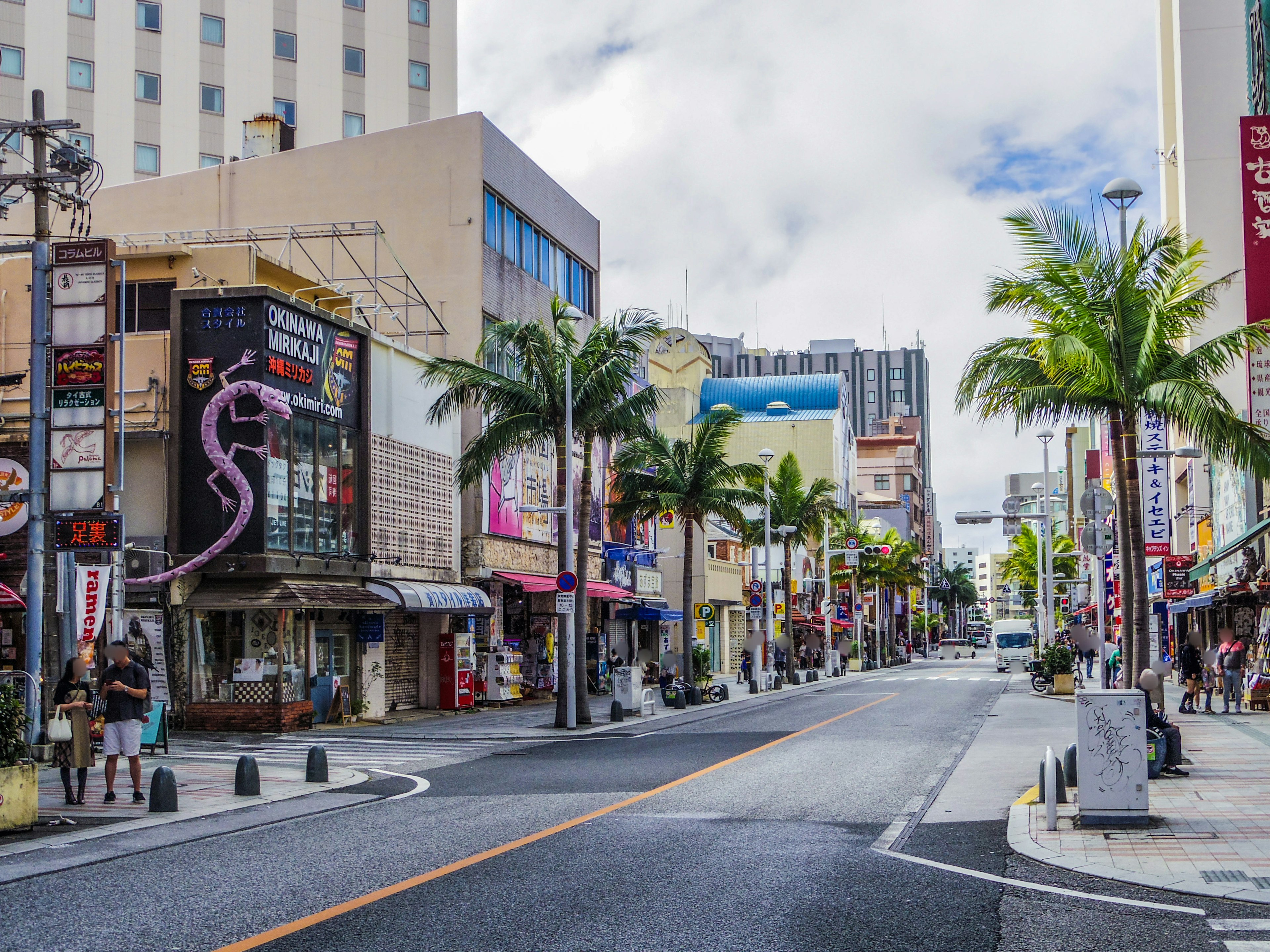 Đường phố ở Okinawa với hàng cây cọ và cửa hàng đầy màu sắc