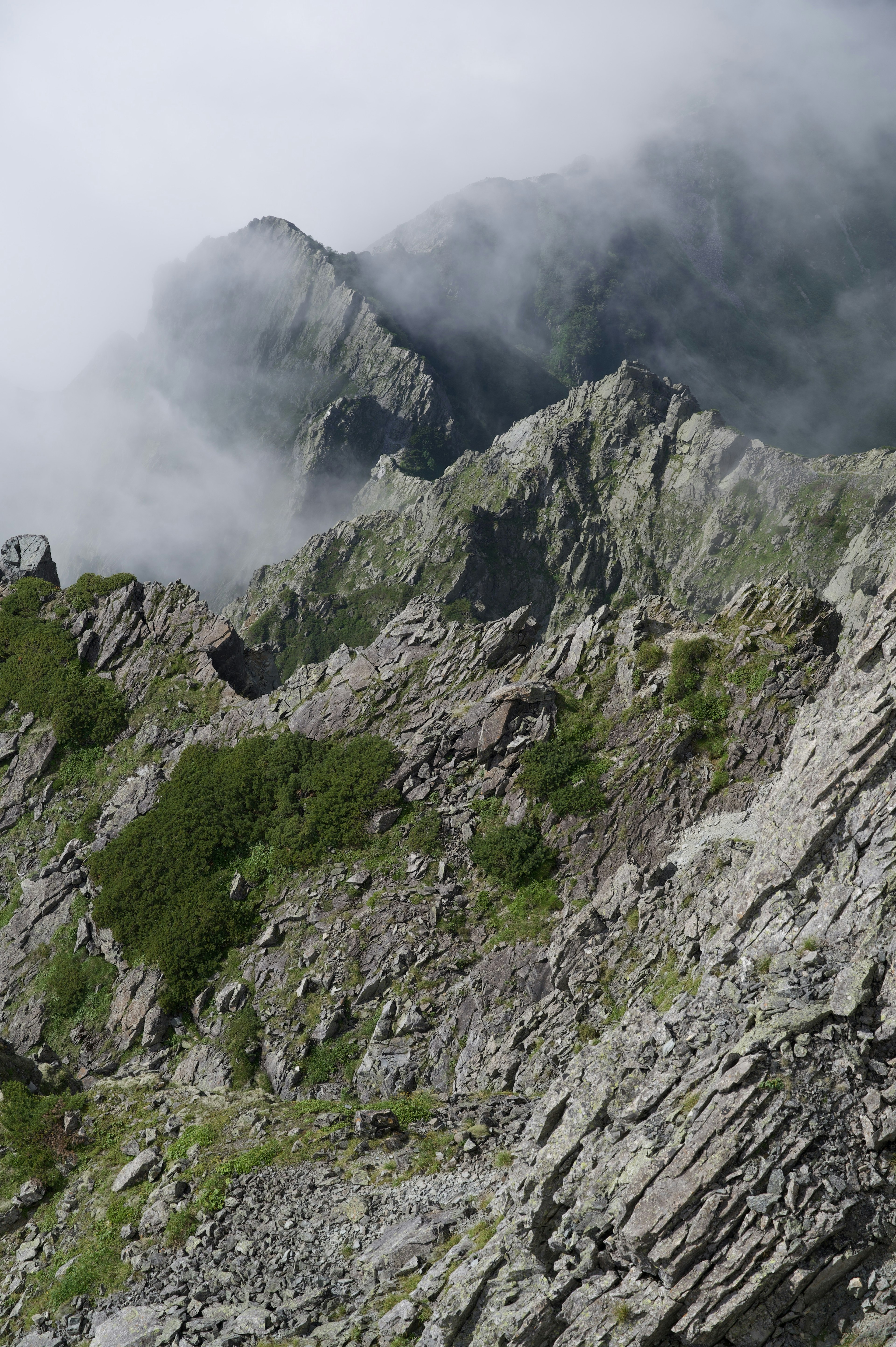 雲に覆われた山の峰と岩の地形