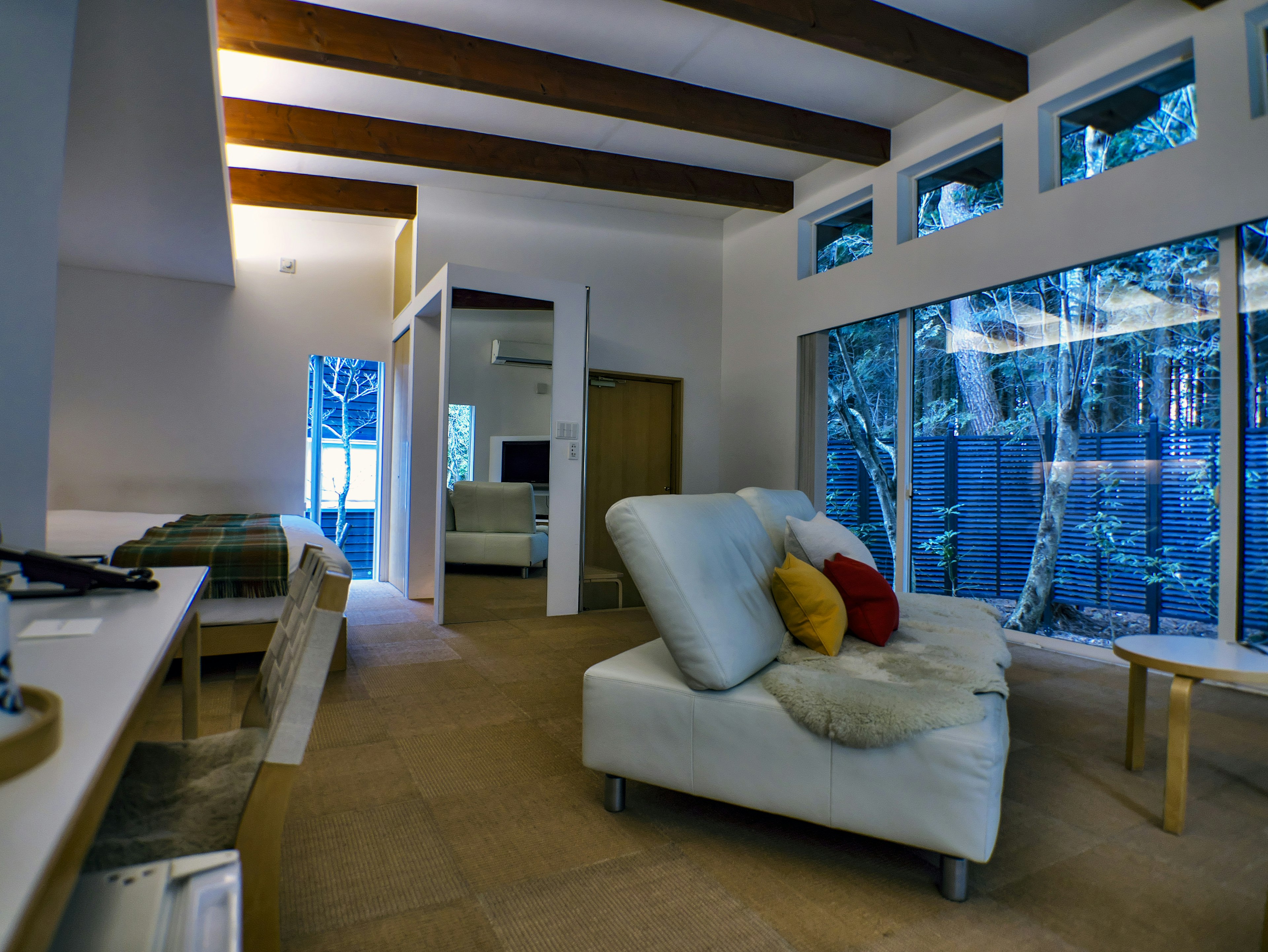 Modern living room interior featuring a stylish sofa and large windows