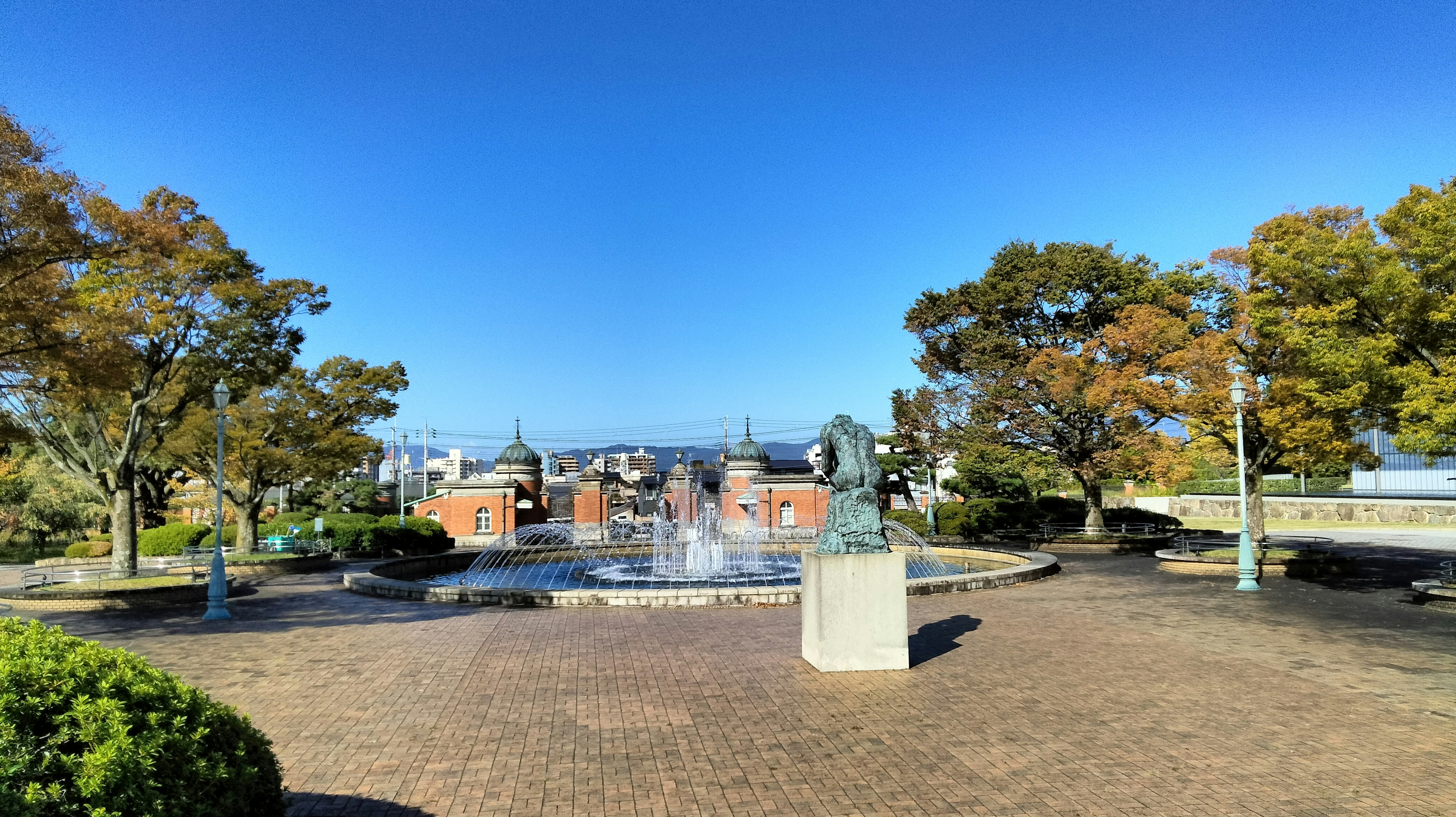 公園の噴水と周囲の木々がある風景