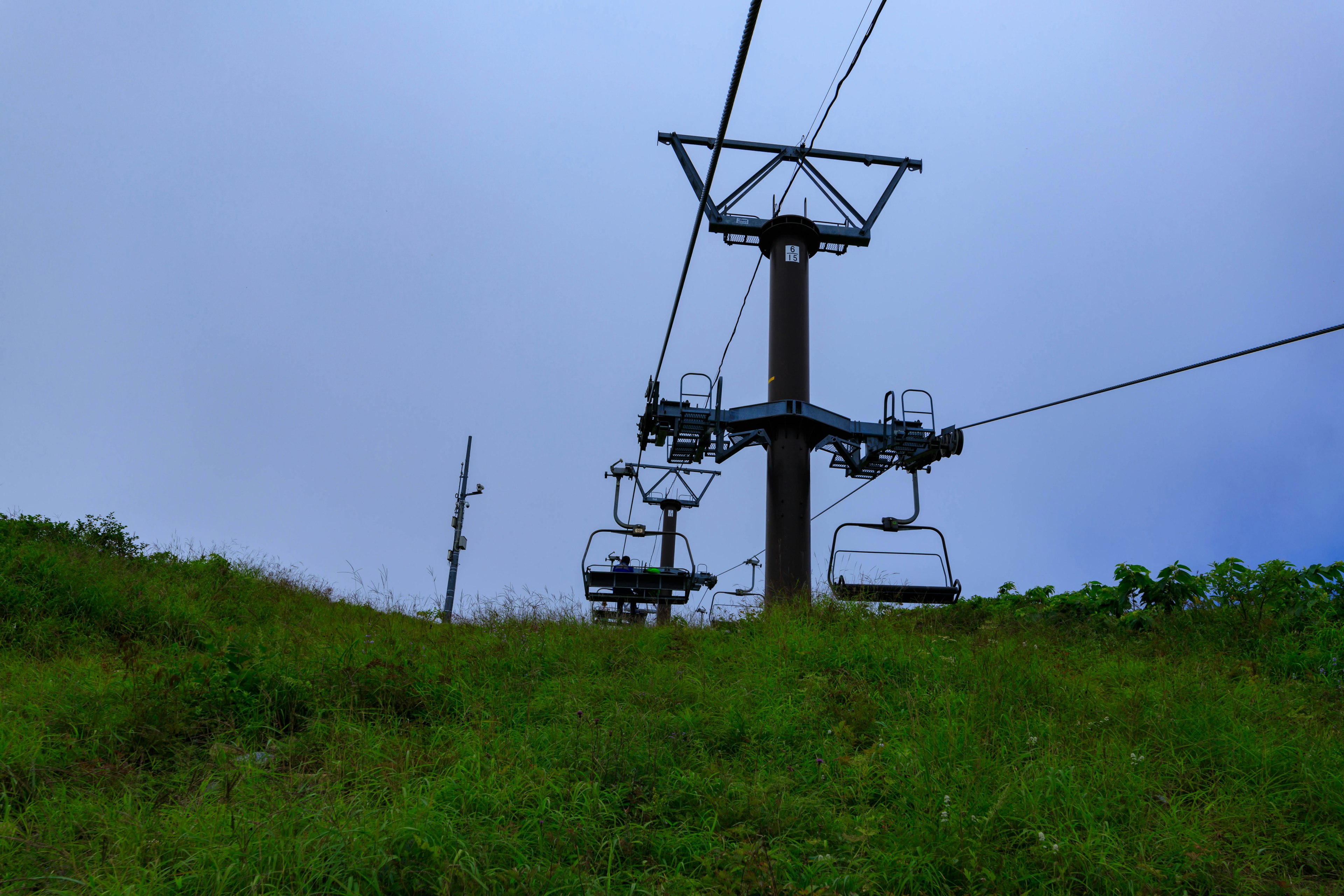 Skiliftstruktur über einem grasbewachsenen Hügel