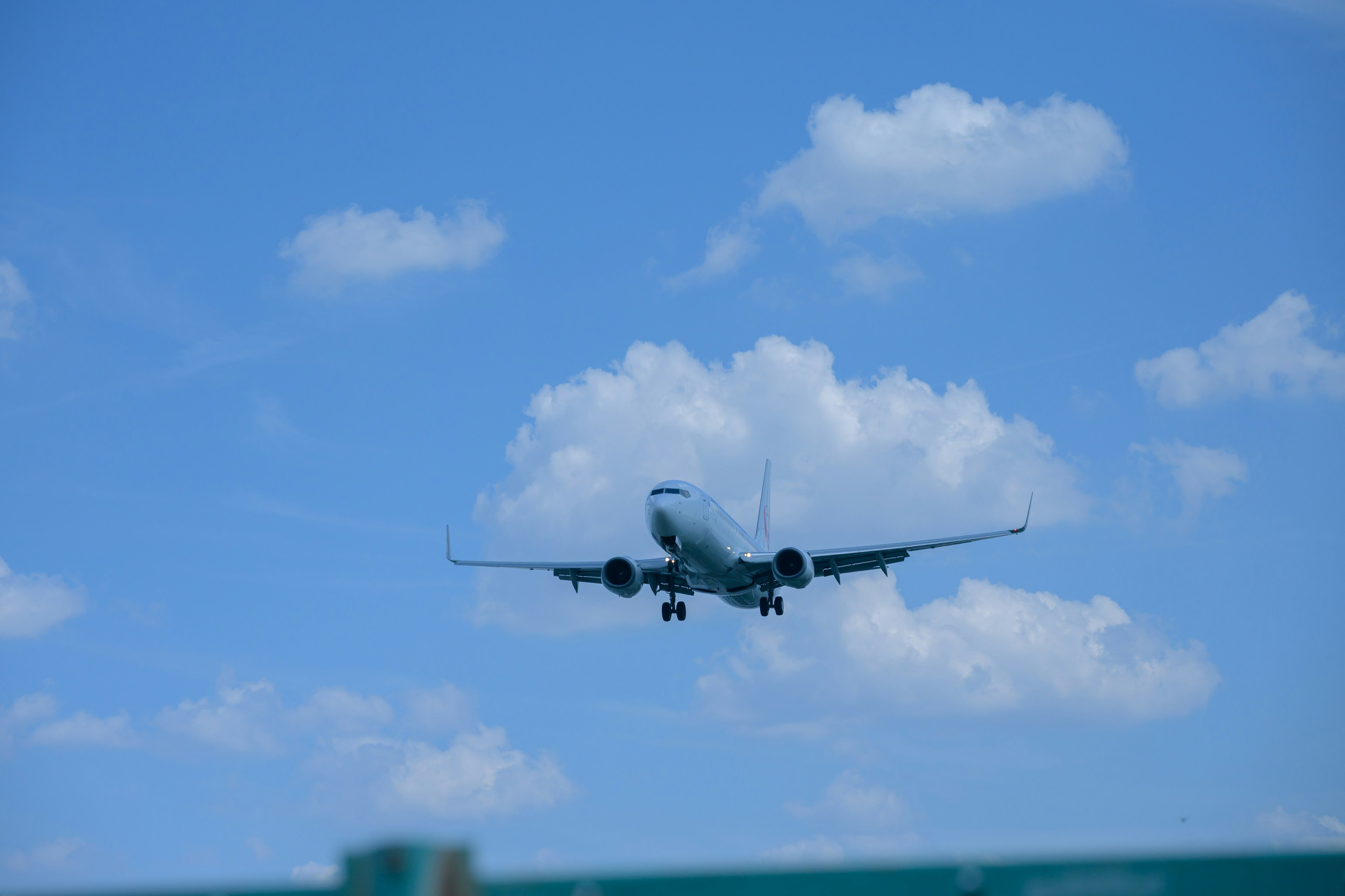 Airplane landing against a bright blue sky