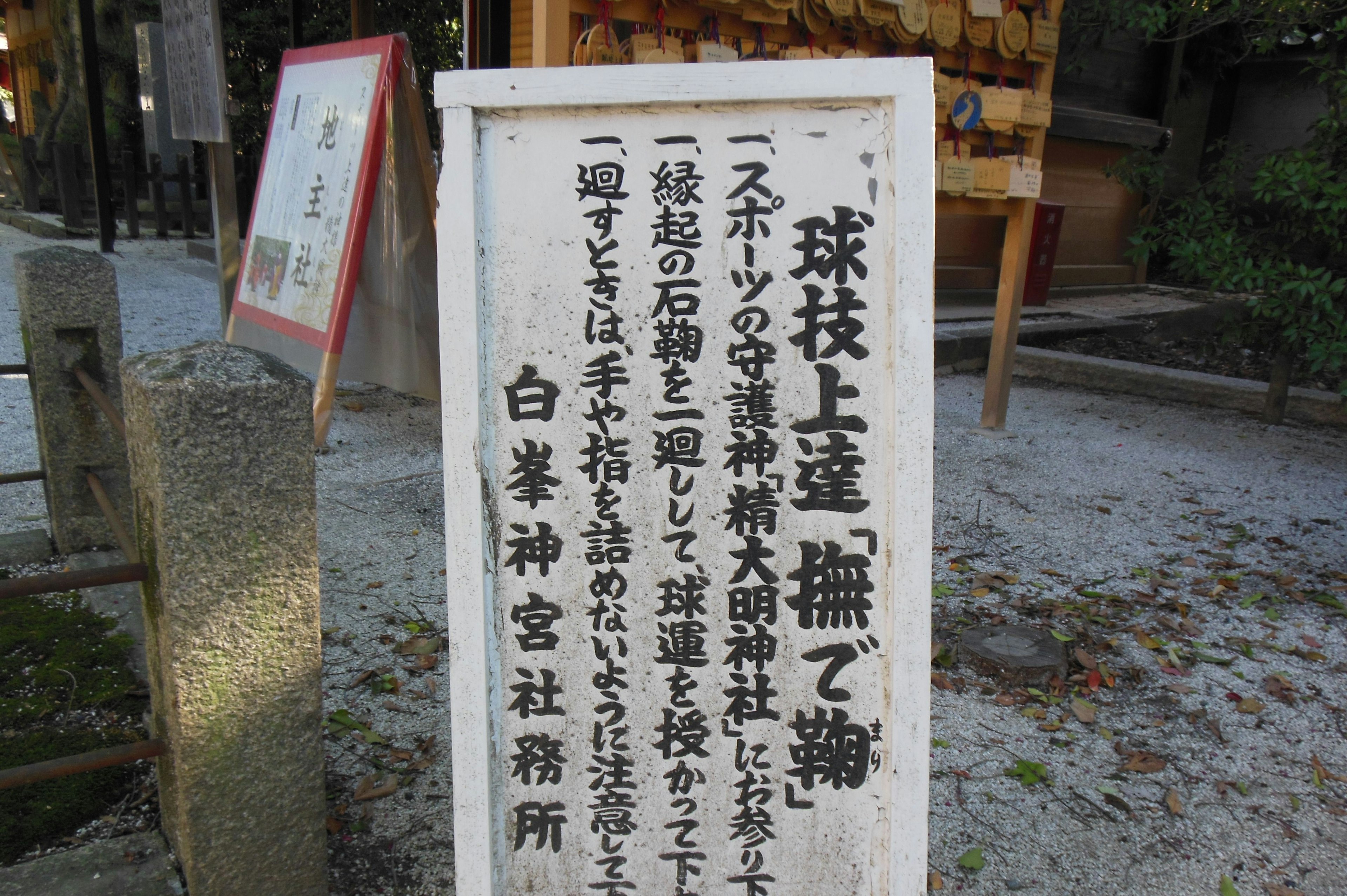 A sign in front of a shrine detailing stone guardians and the shrine's name