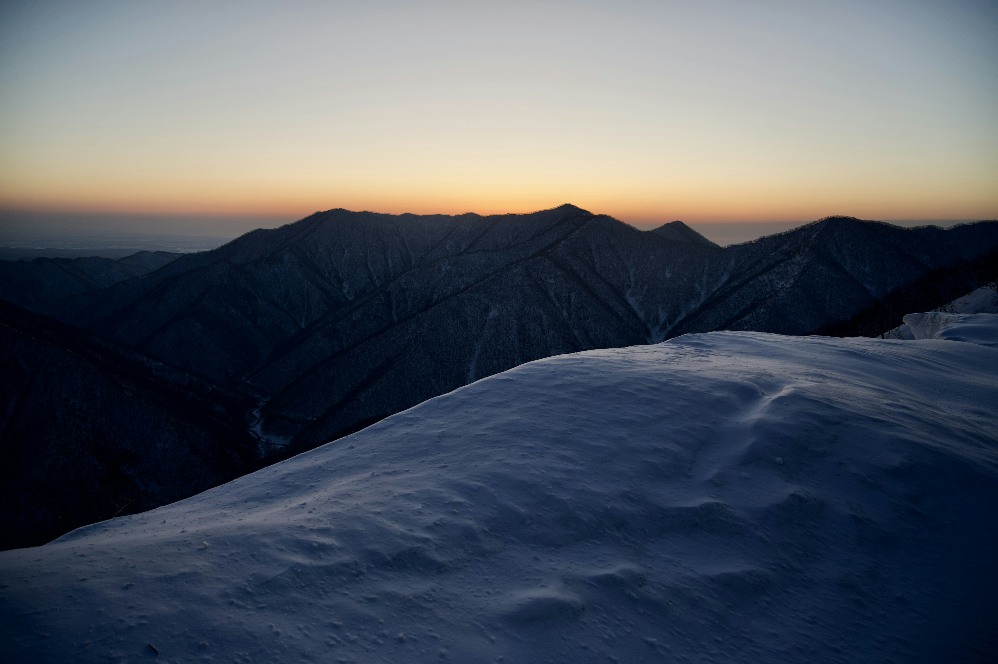 雪に覆われた山の頂上からの美しい夕焼けの景色