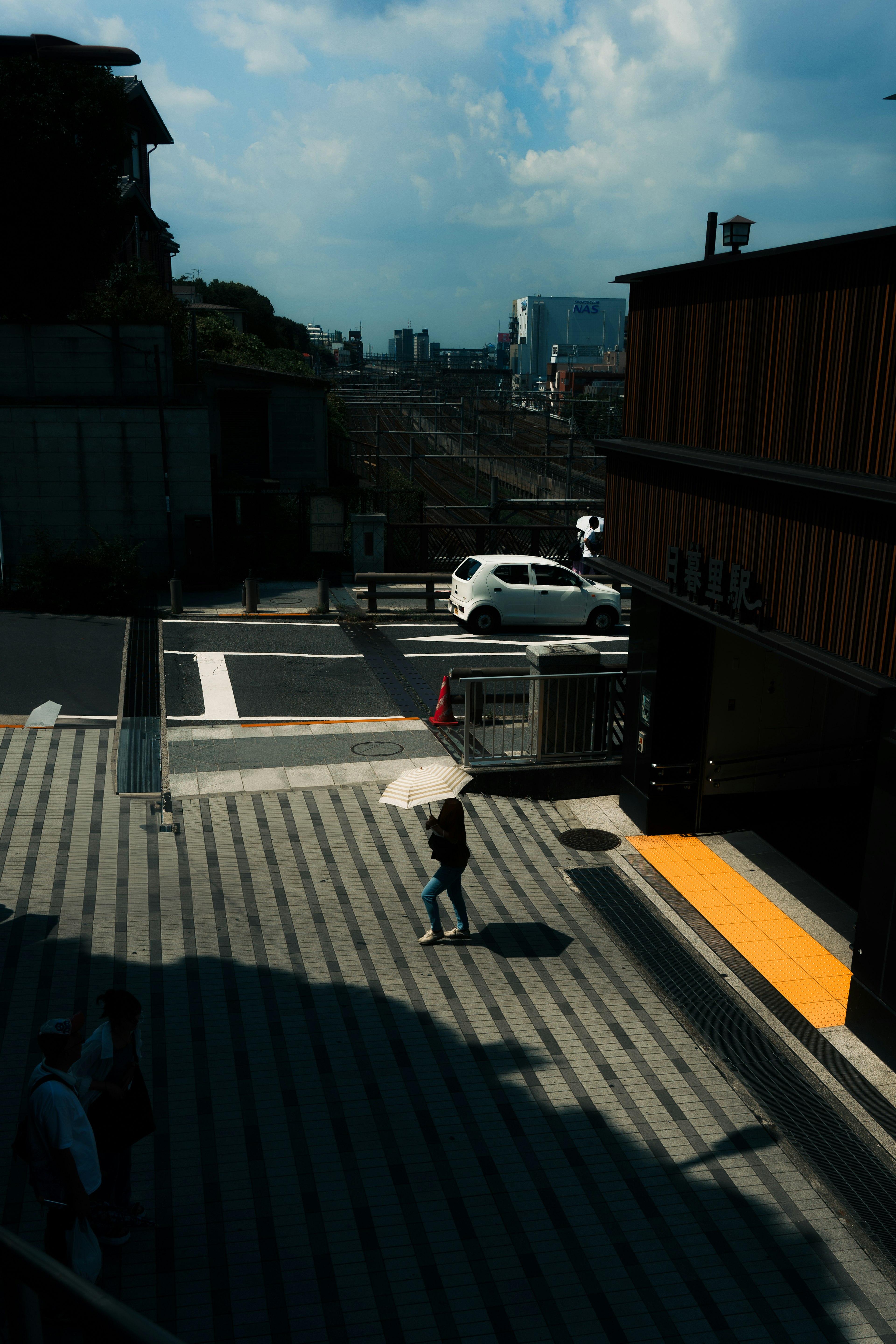 Urban scene featuring a person with an umbrella walking down stairs