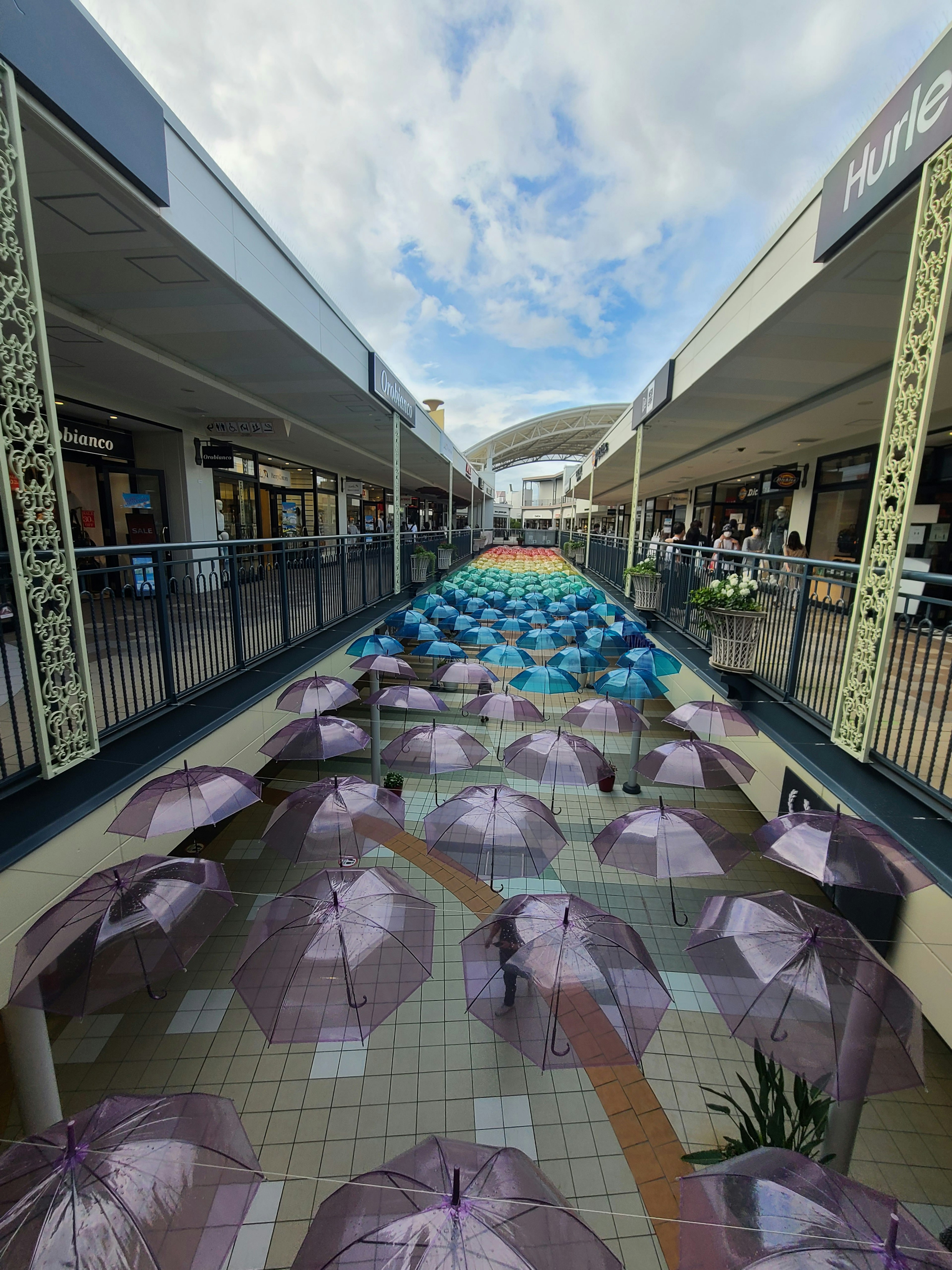 Installazione artistica di ombrelli colorati in un corridoio coperto