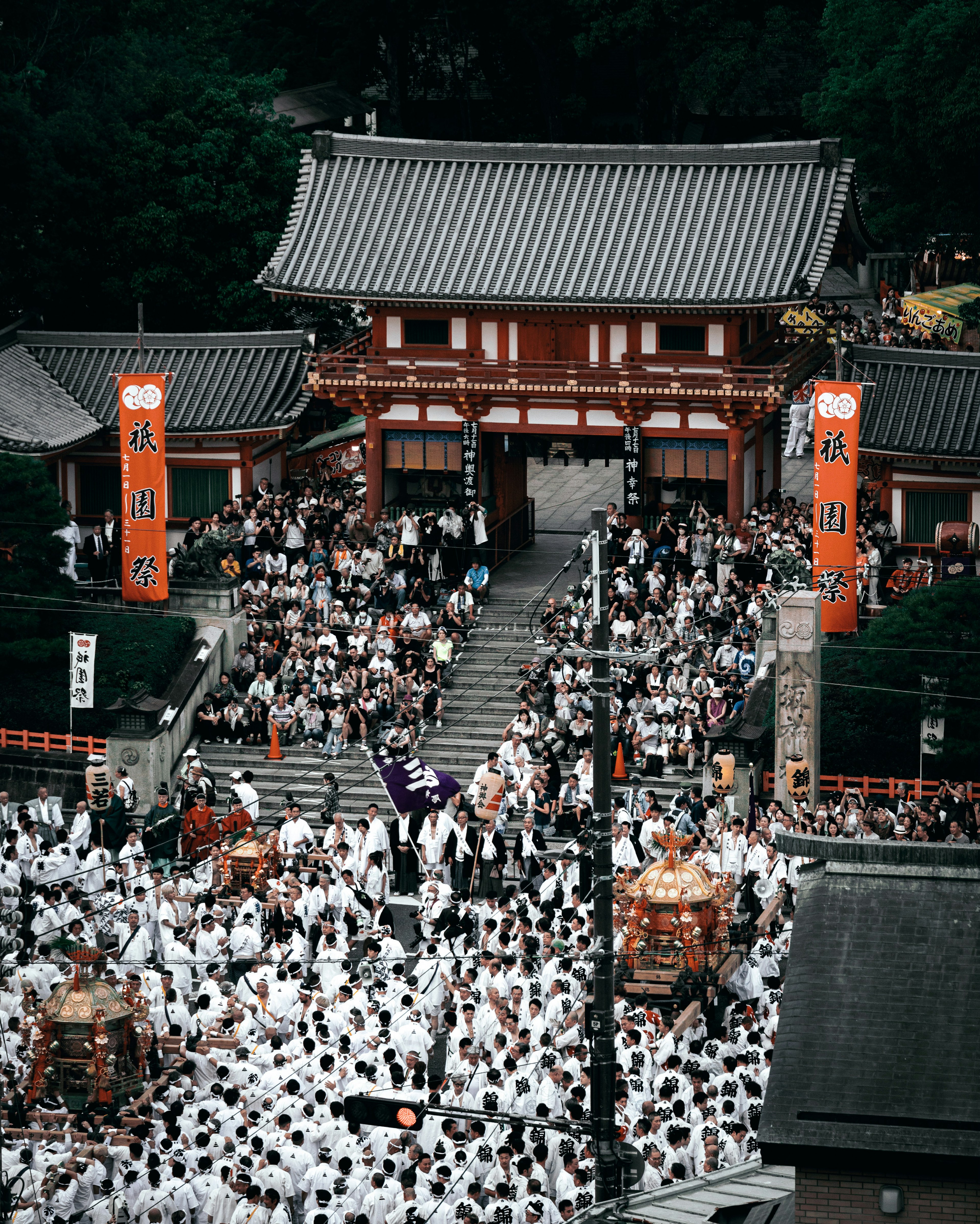 身穿白色服装的人群聚集在神社节日