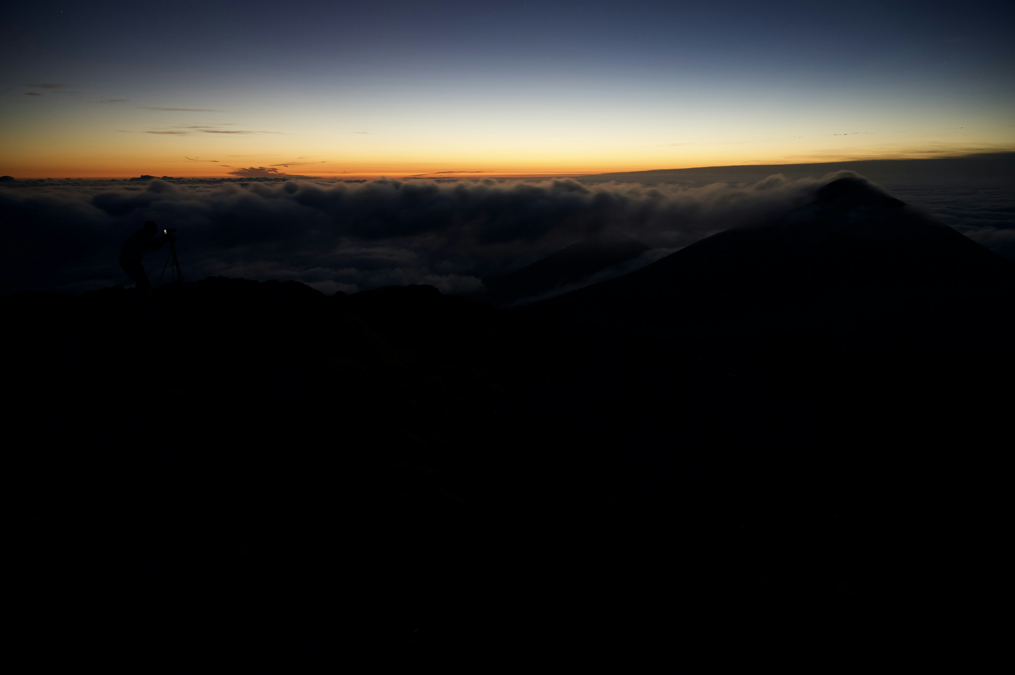 山のシルエットと雲の上の朝焼けの風景