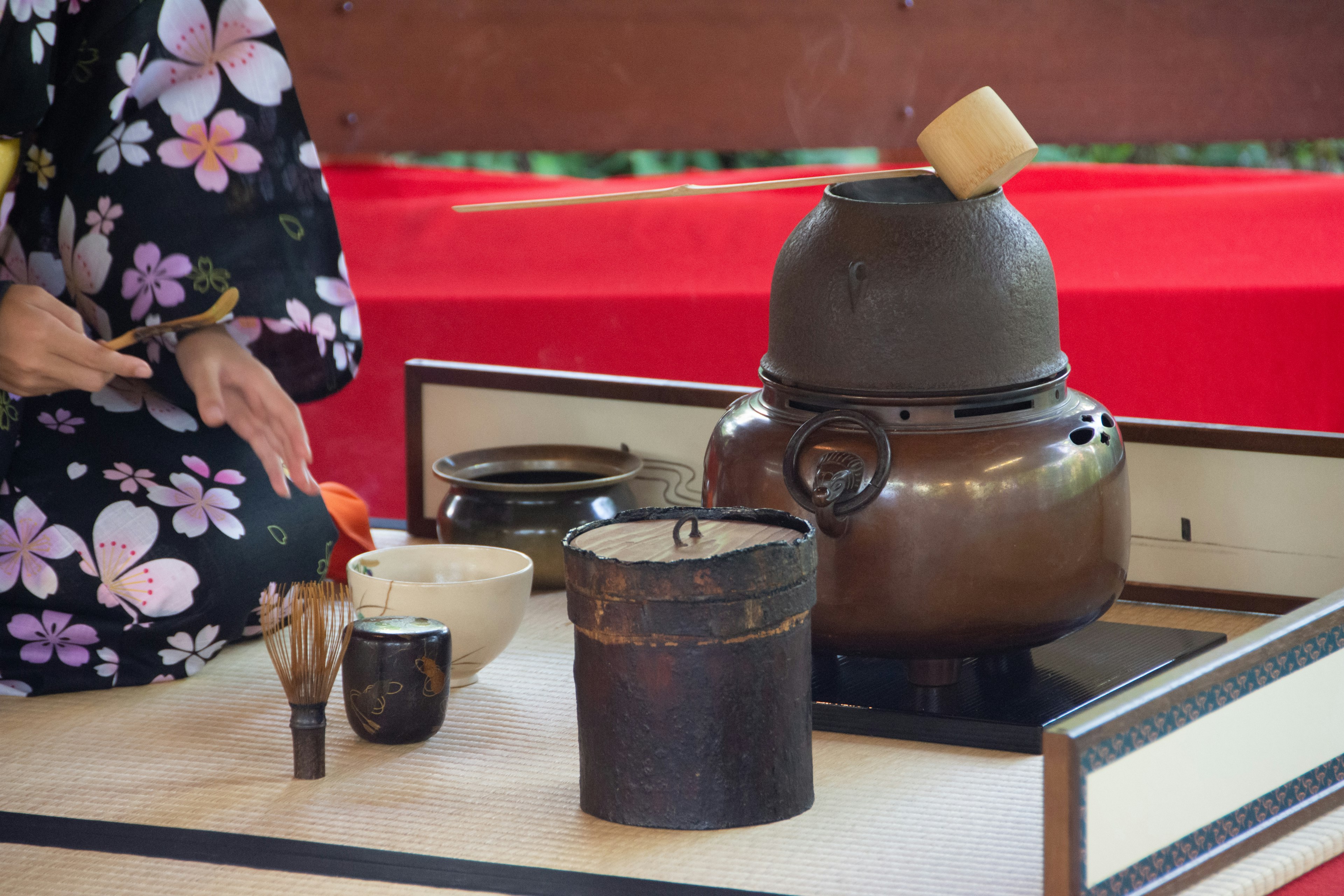 Una donna in kimono che prepara il tè con strumenti tradizionali per la cerimonie del tè