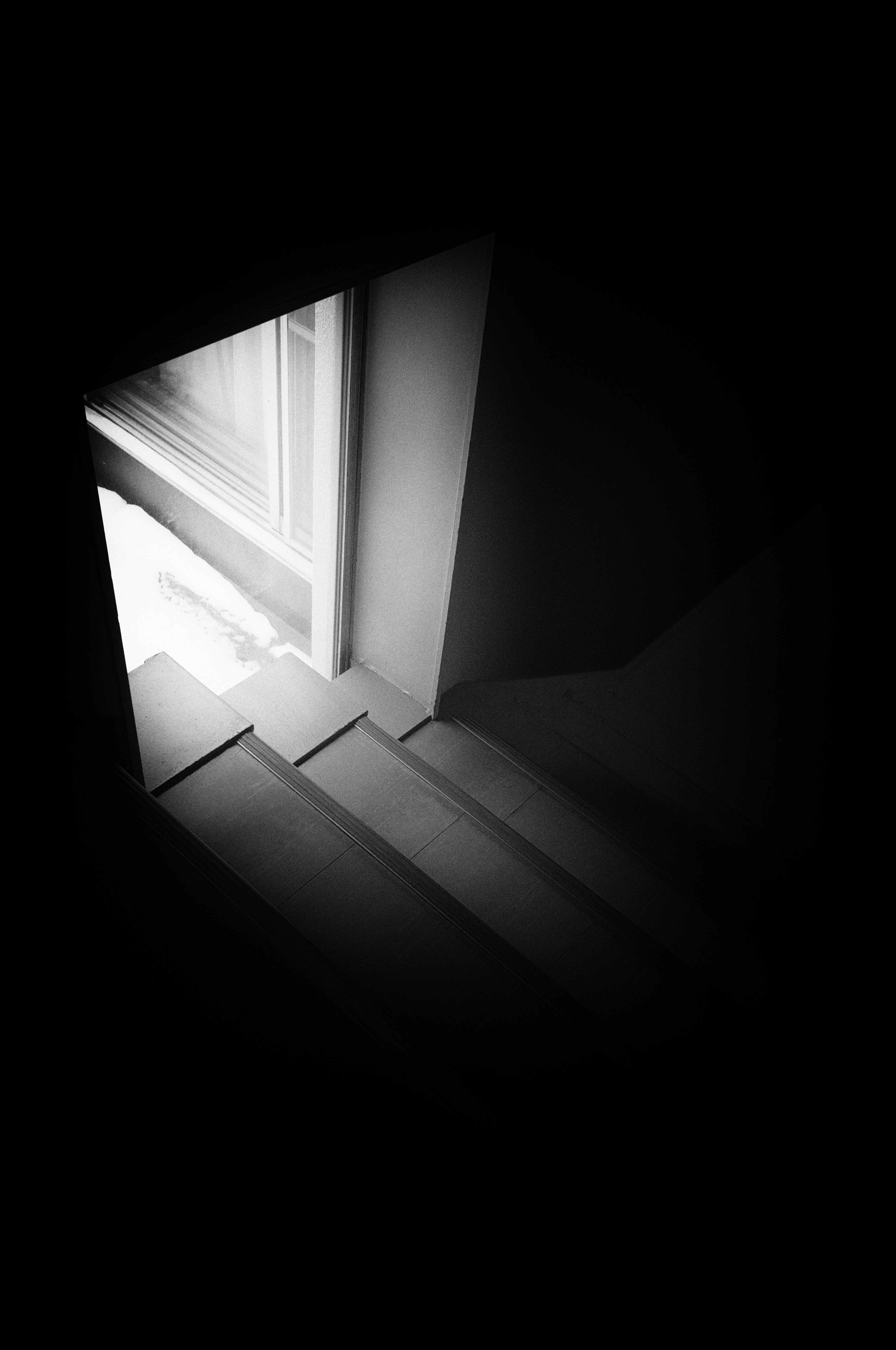 Imagen en blanco y negro que muestra la intersección de sombras y luz en las escaleras