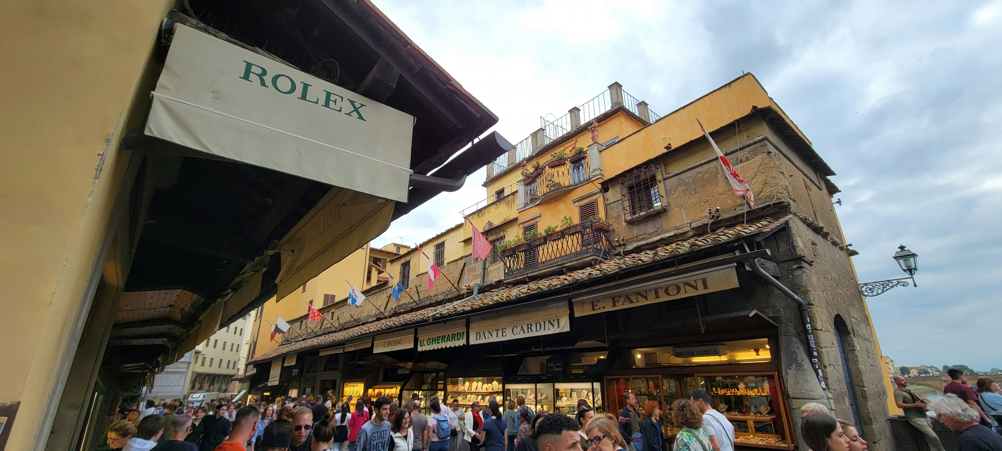 Scena vivace di un mercato a Firenze con architettura storica e folla di persone