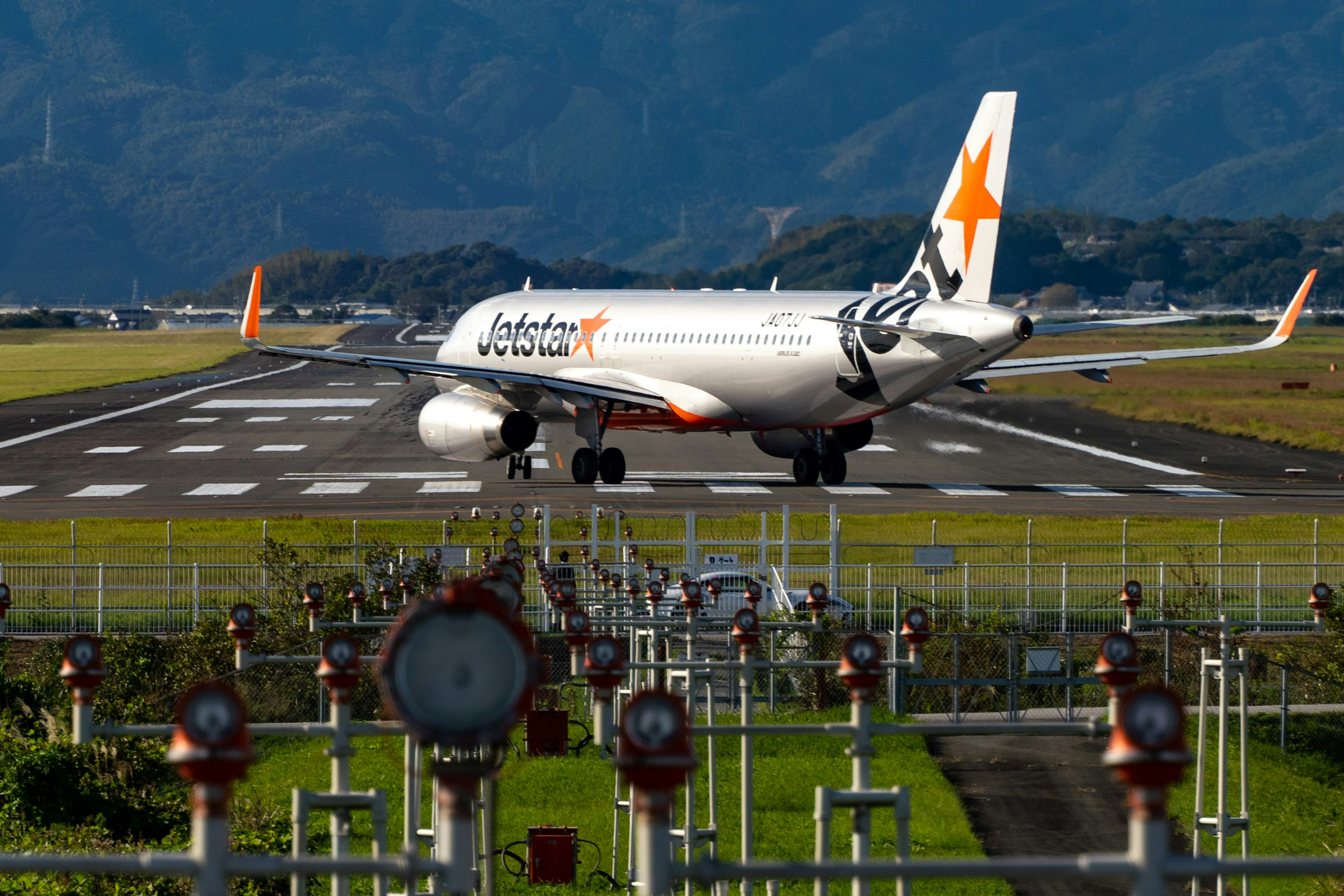 Flugzeug, das auf der Landebahn rollt mit Flughafenanlagen