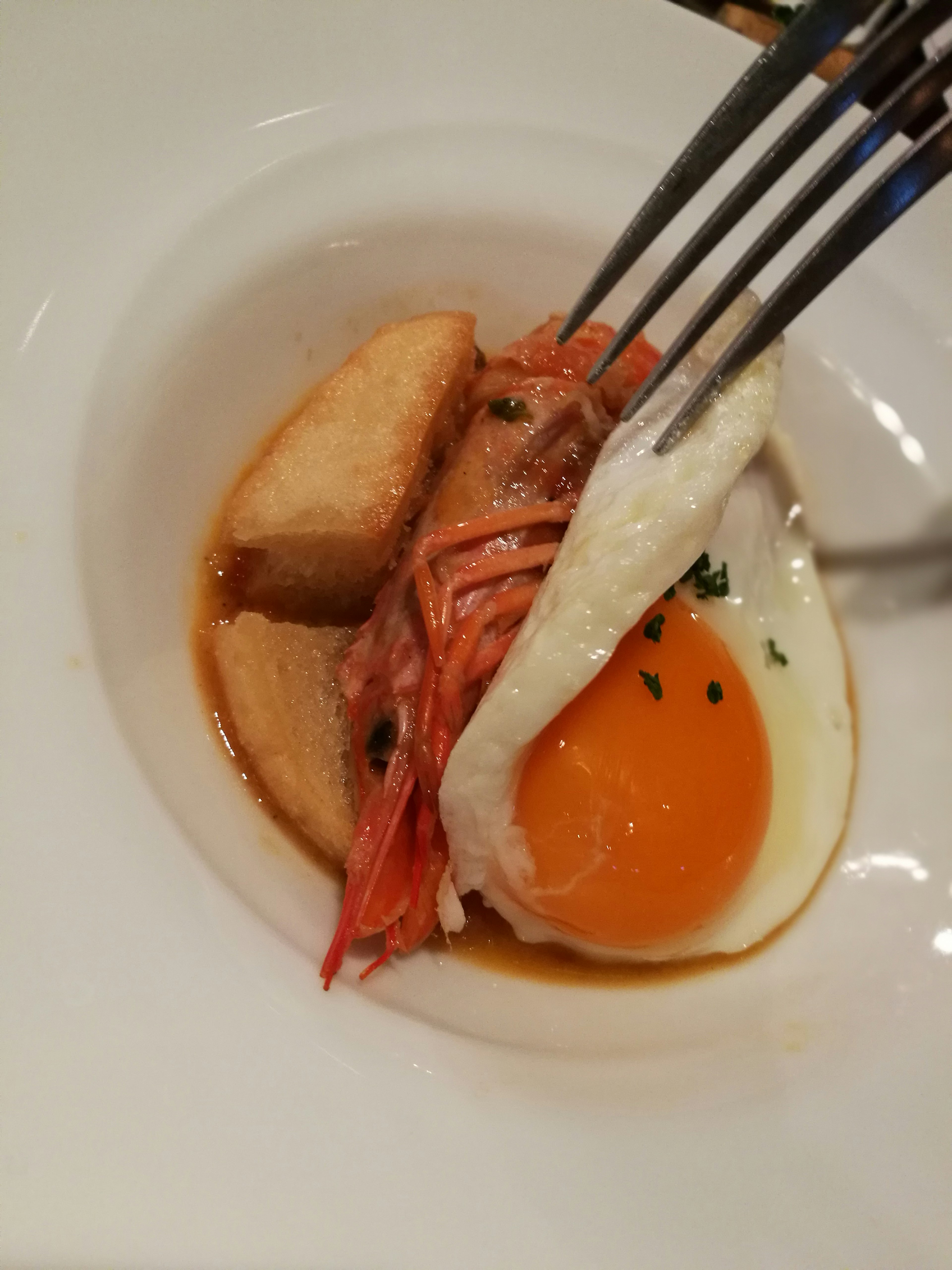 Un plat avec un œuf au plat, des légumes et des pommes de terre