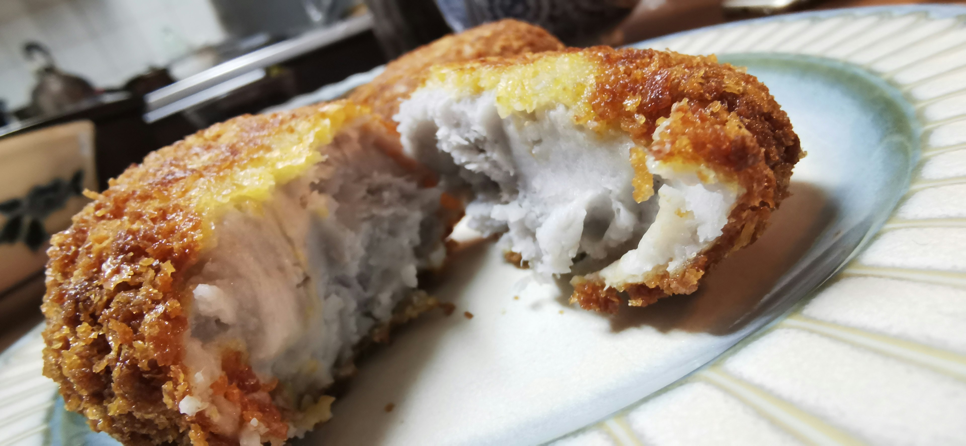 Potongan silang kroket goreng yang memperlihatkan isian krim di dalamnya