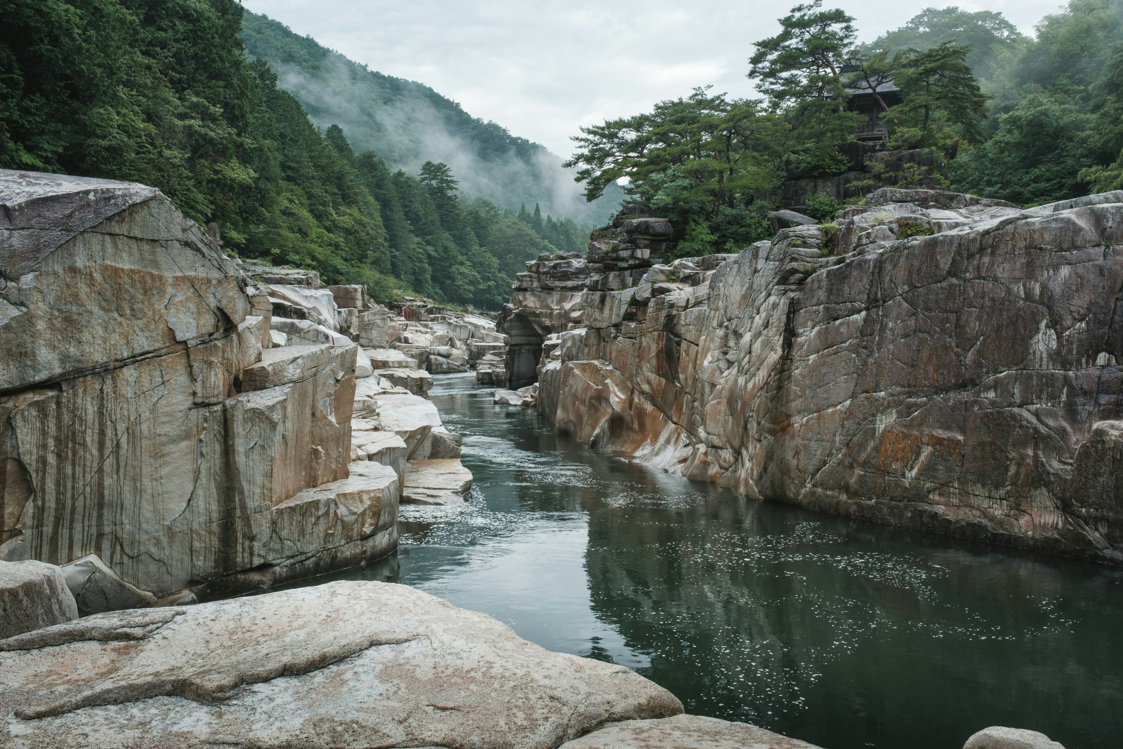 静かな川が岩と緑に囲まれた風景