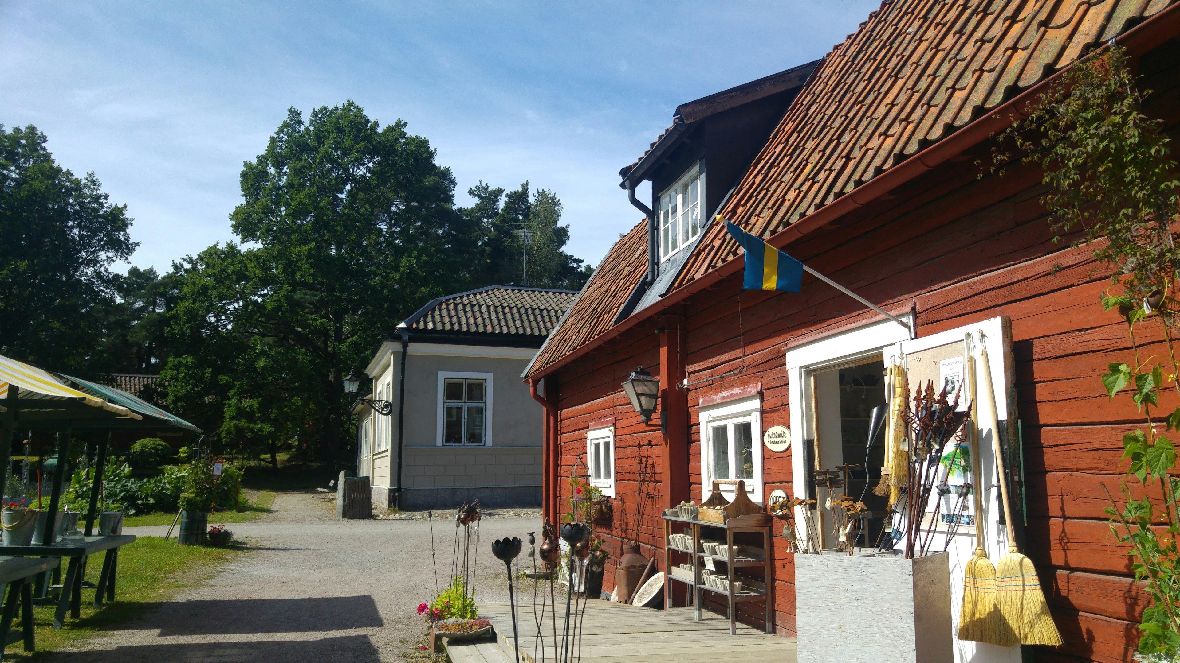 赤い木造の家とスウェーデンの国旗が見える風景