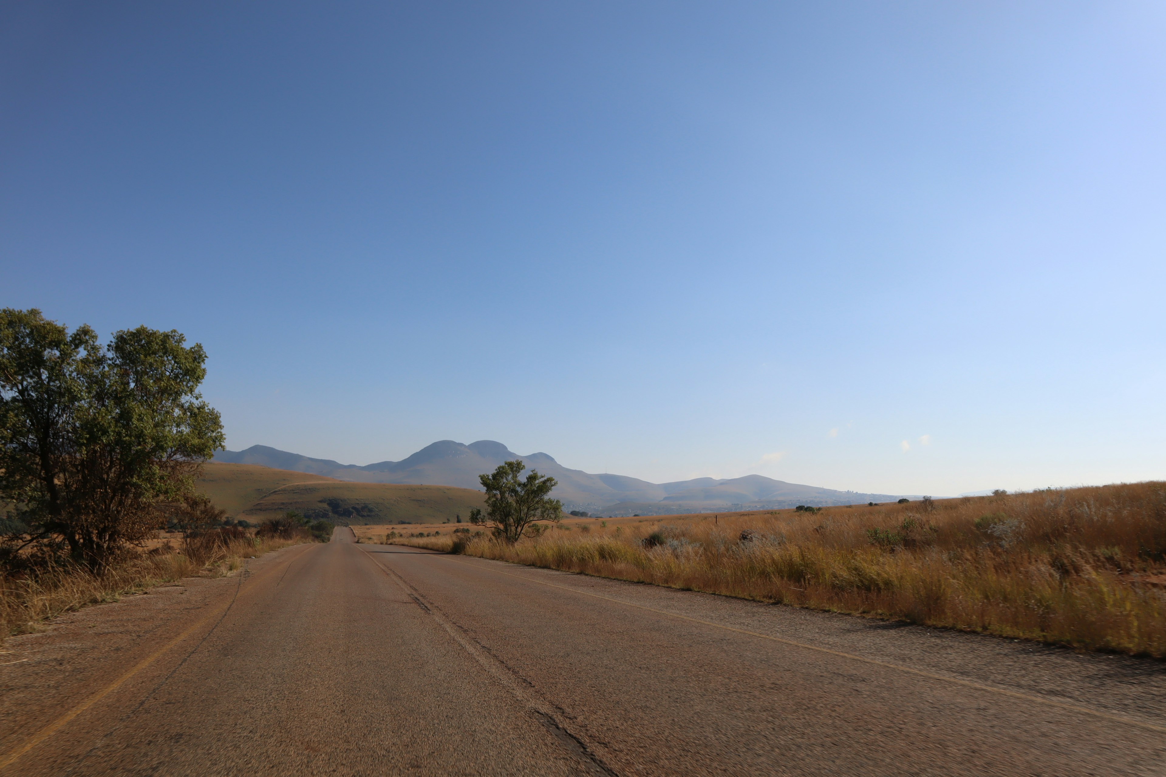 Vista panoramica di una strada aperta con montagne e cielo azzurro