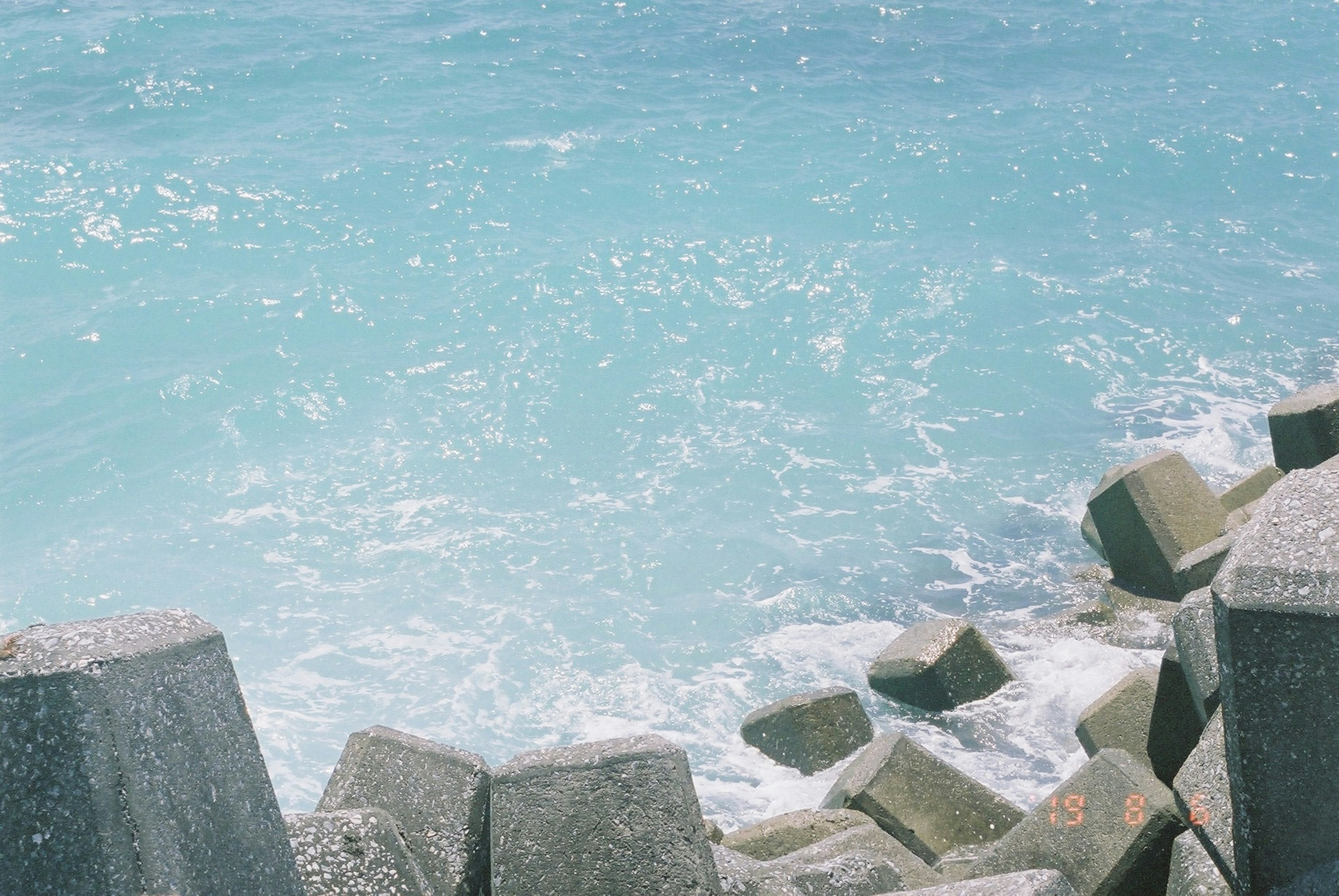 Blue ocean with tetrapods along the shore