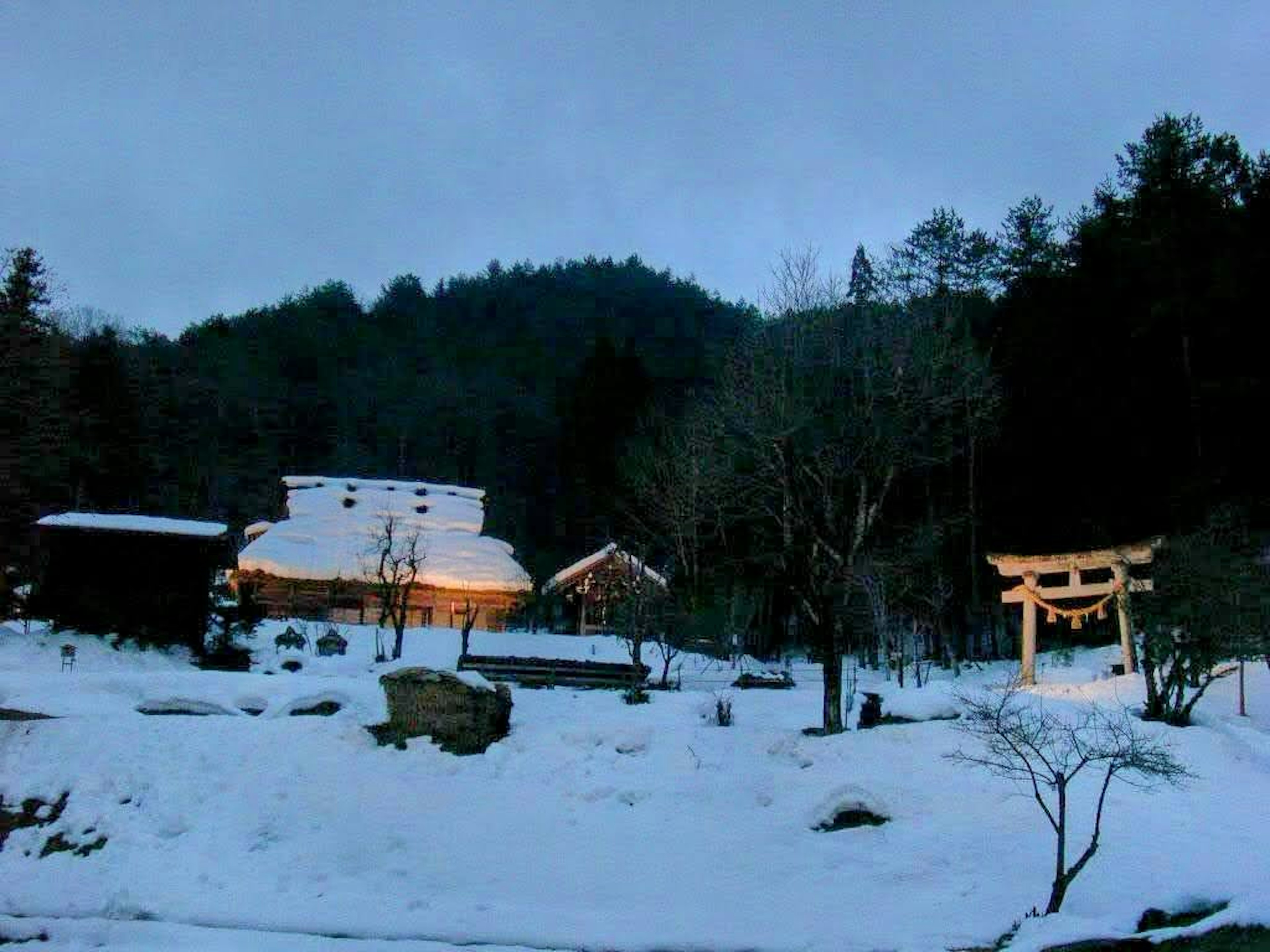 Scenic view of a shrine and houses covered in snow in the mountains