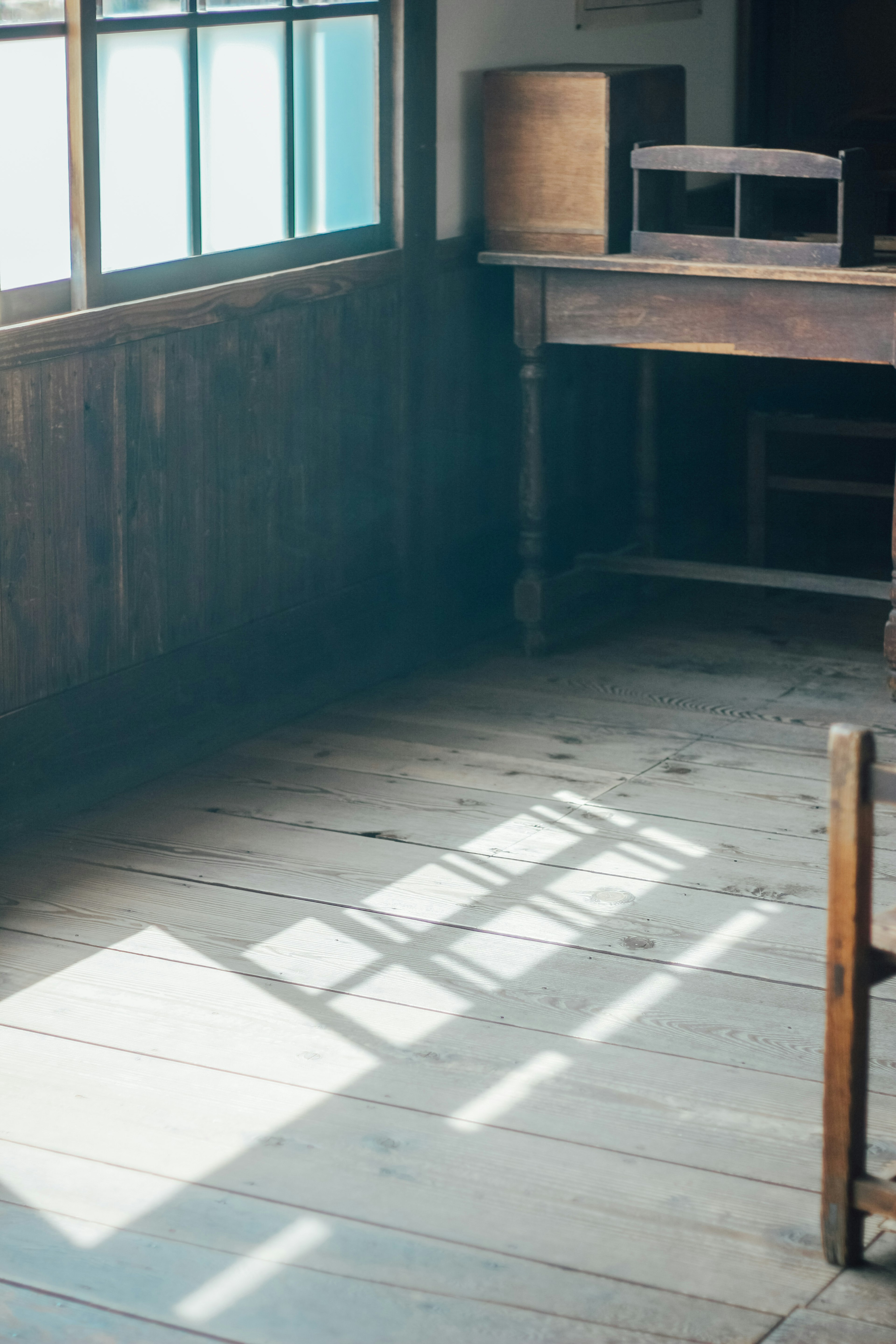 Une pièce calme avec un sol en bois et une lumière réfléchie par la fenêtre