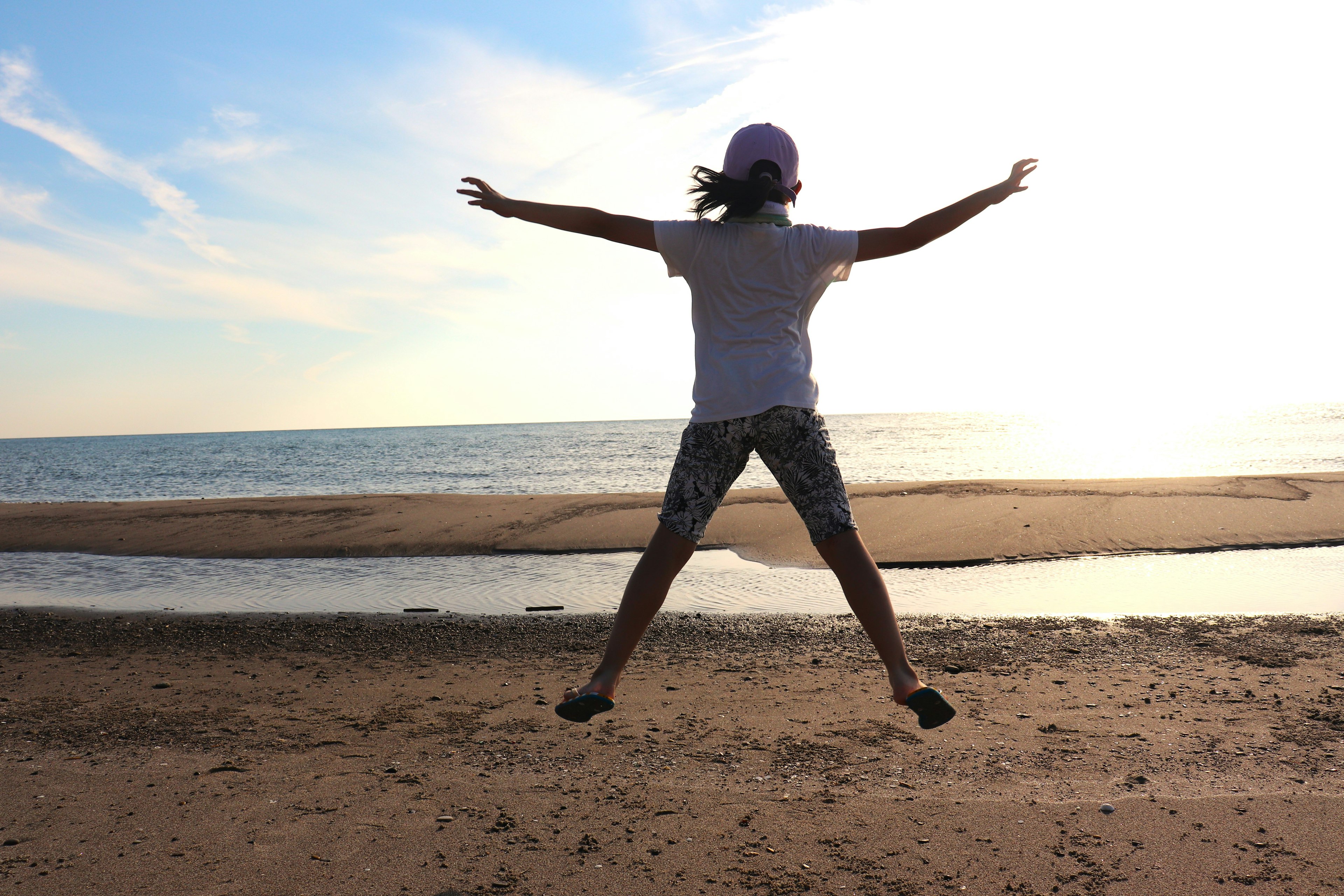 Silhouette eines Kindes, das am Strand springt