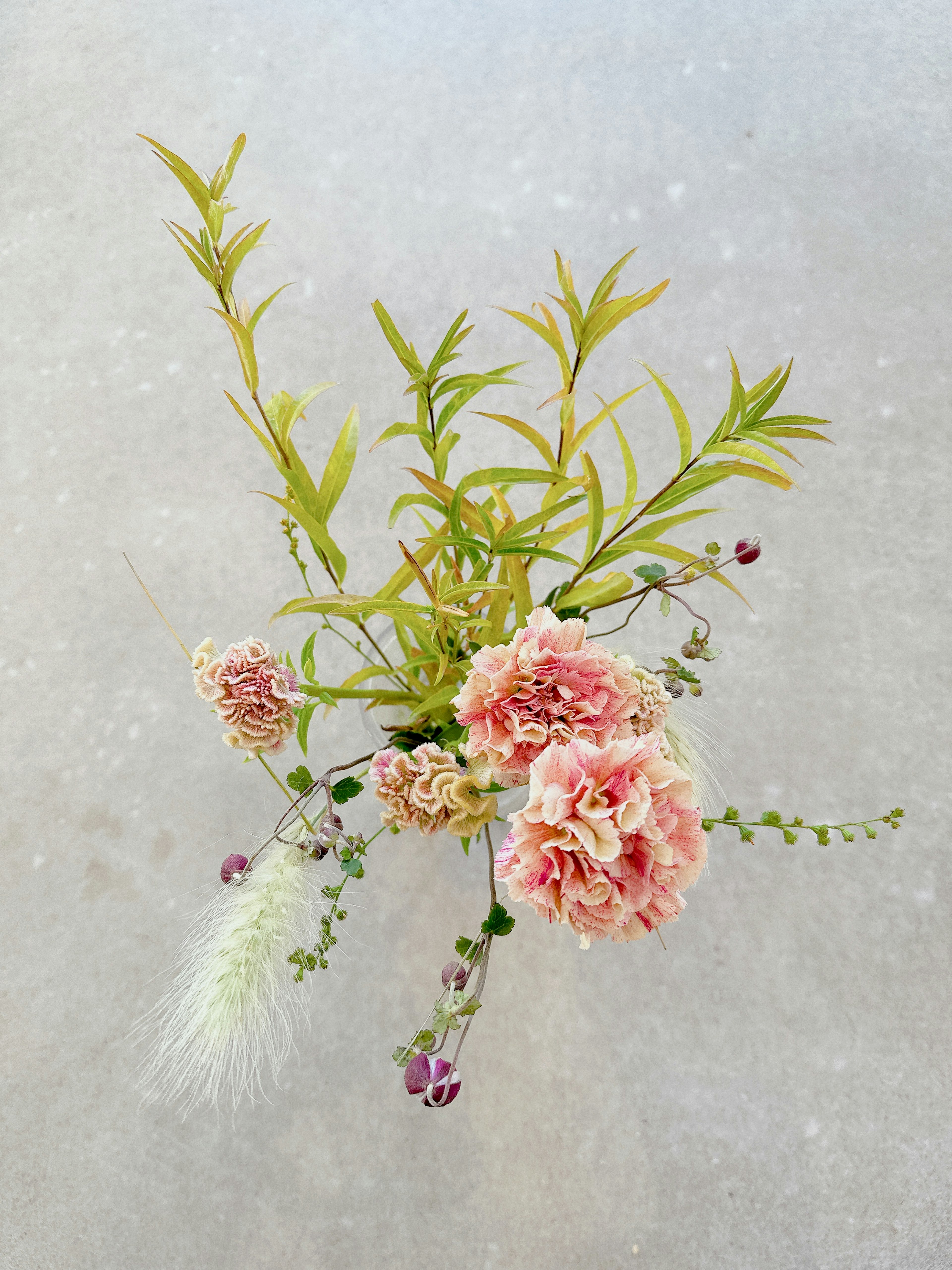 Un bellissimo bouquet con garofani rosa chiaro e foglie verdi