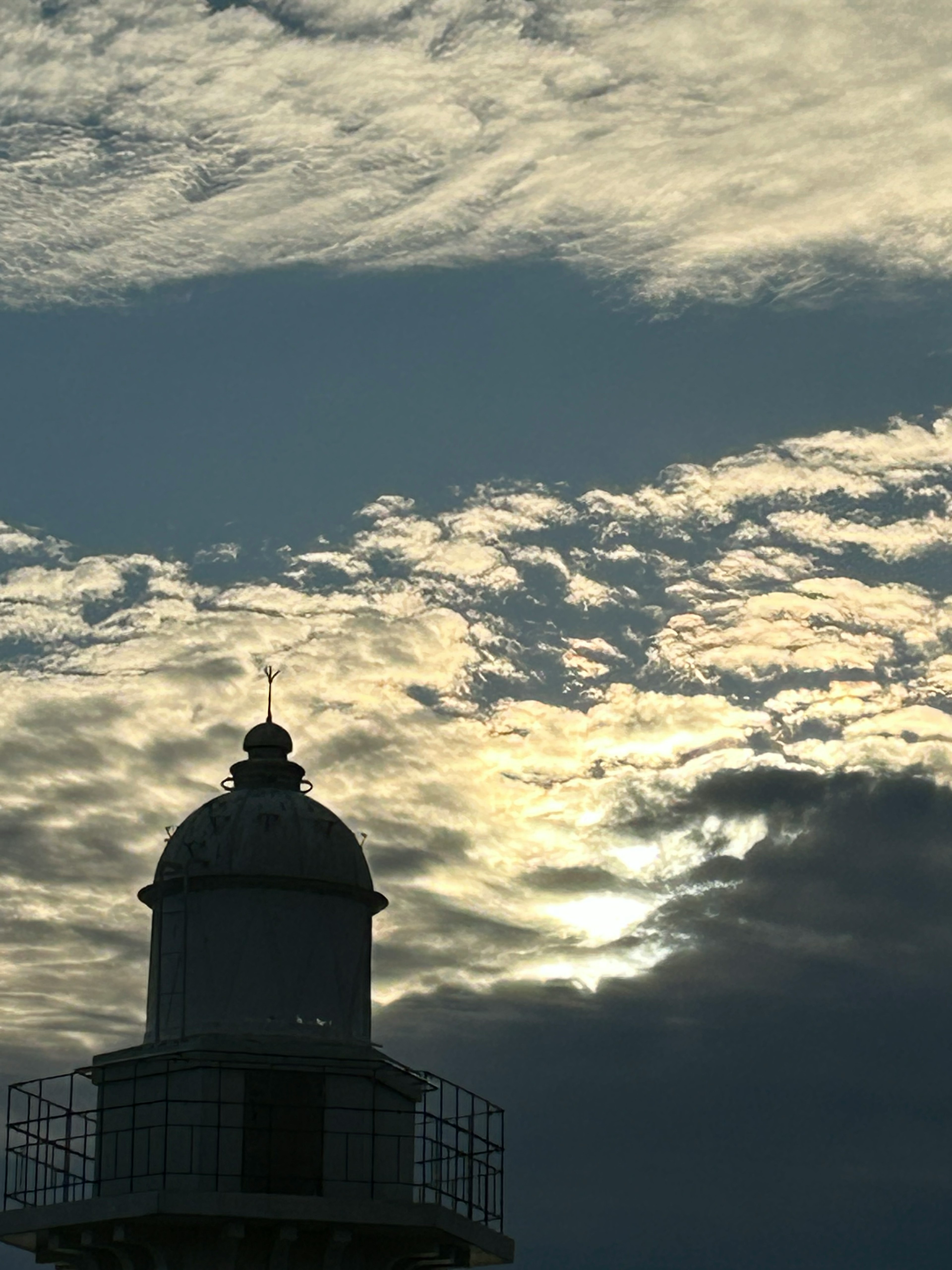 Faro en silueta contra un cielo dramático al atardecer