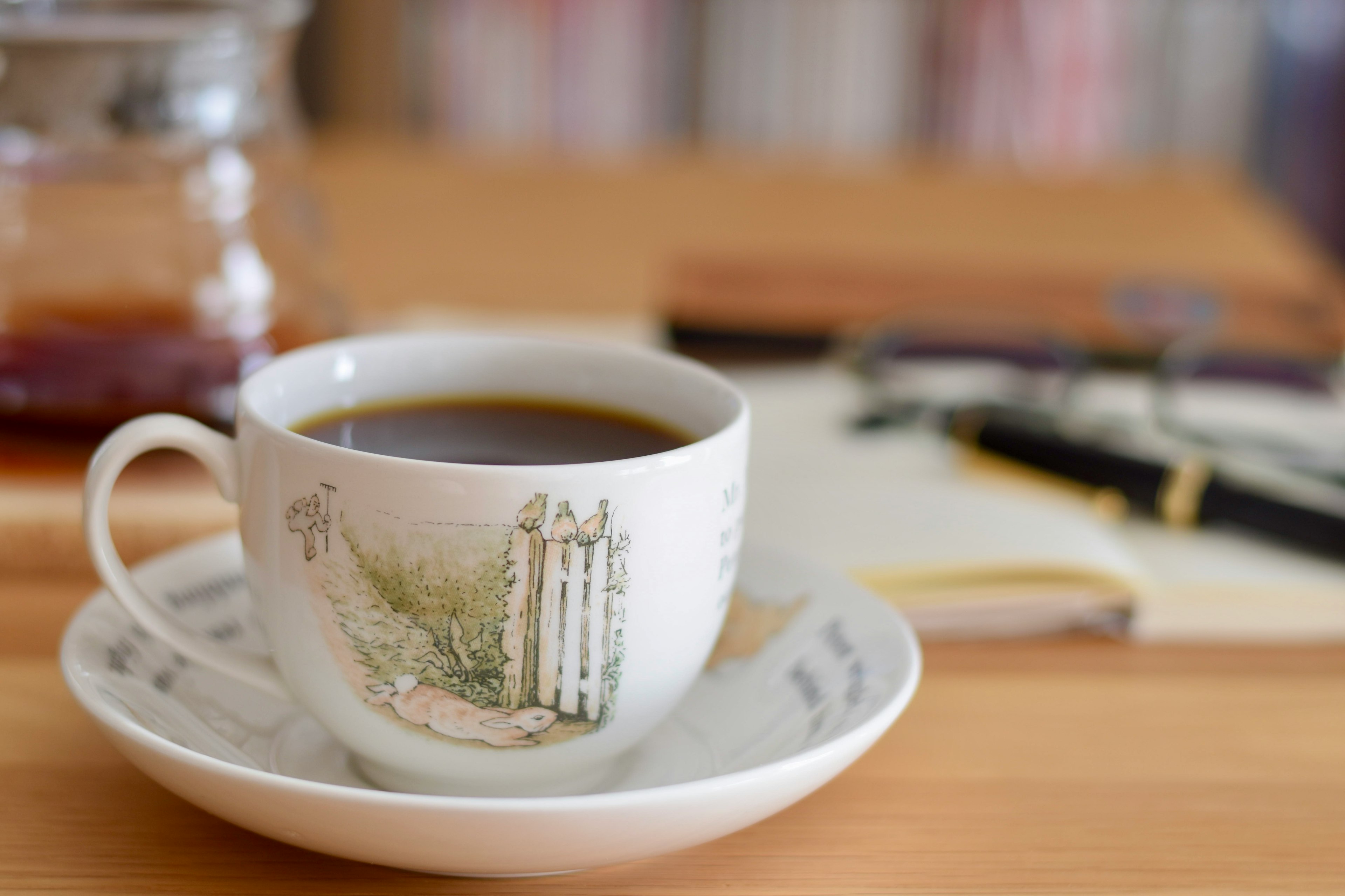 Café en una taza de diseño elegante sobre un platillo colocado en una mesa de madera