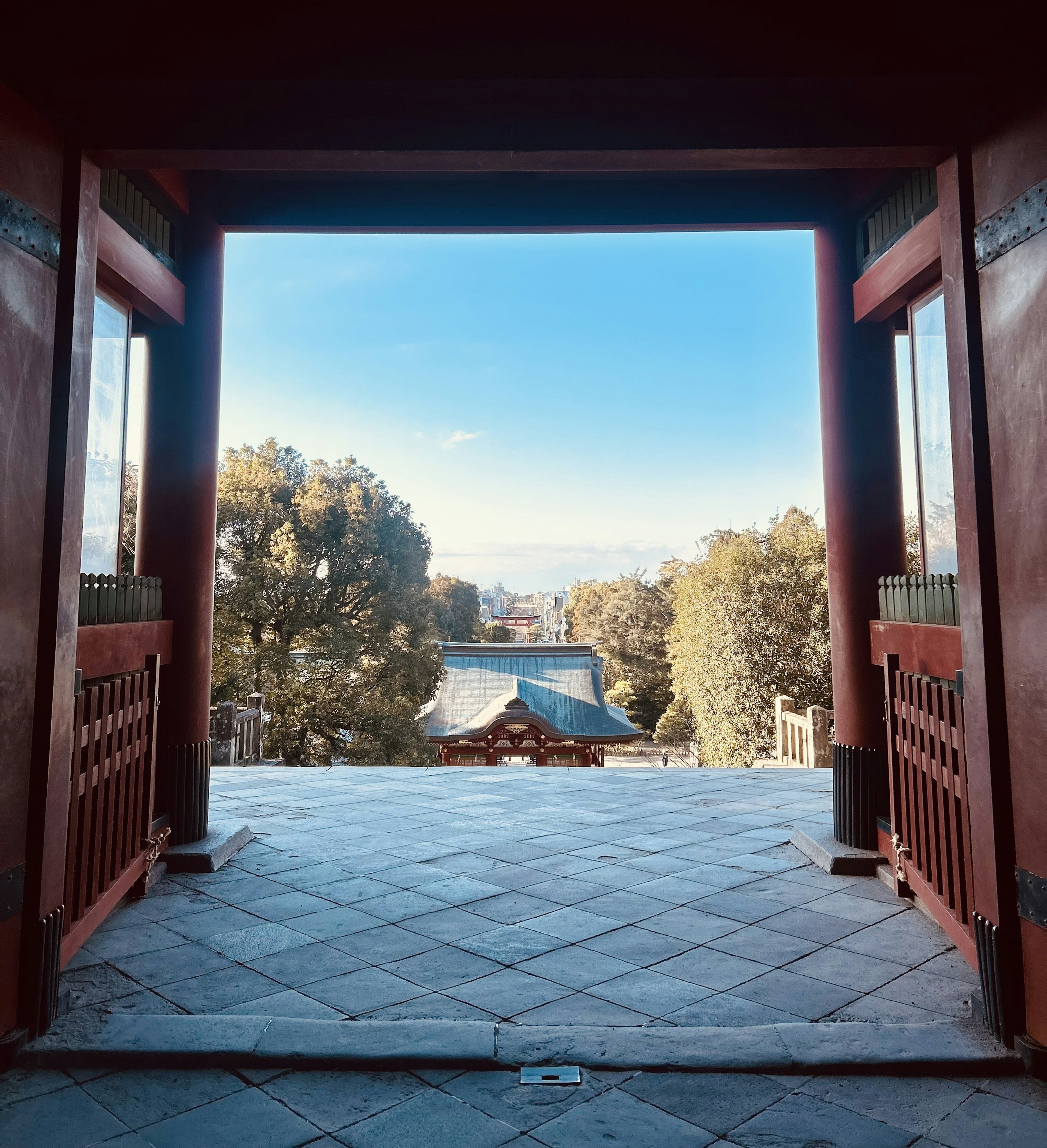 Vue à travers une porte rouge mettant en valeur un paysage magnifique et un ciel bleu