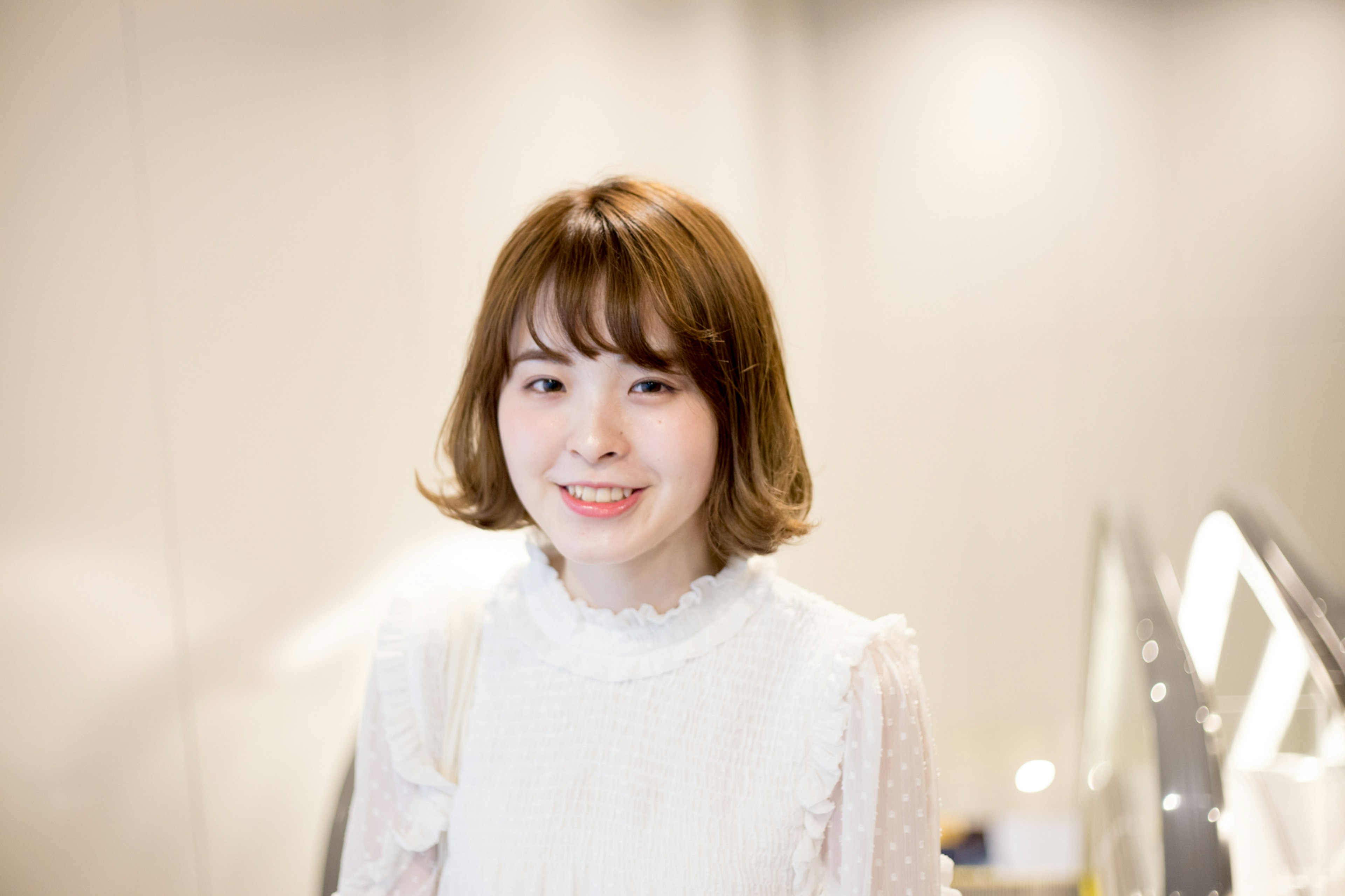 Una joven sonriente con blusa blanca