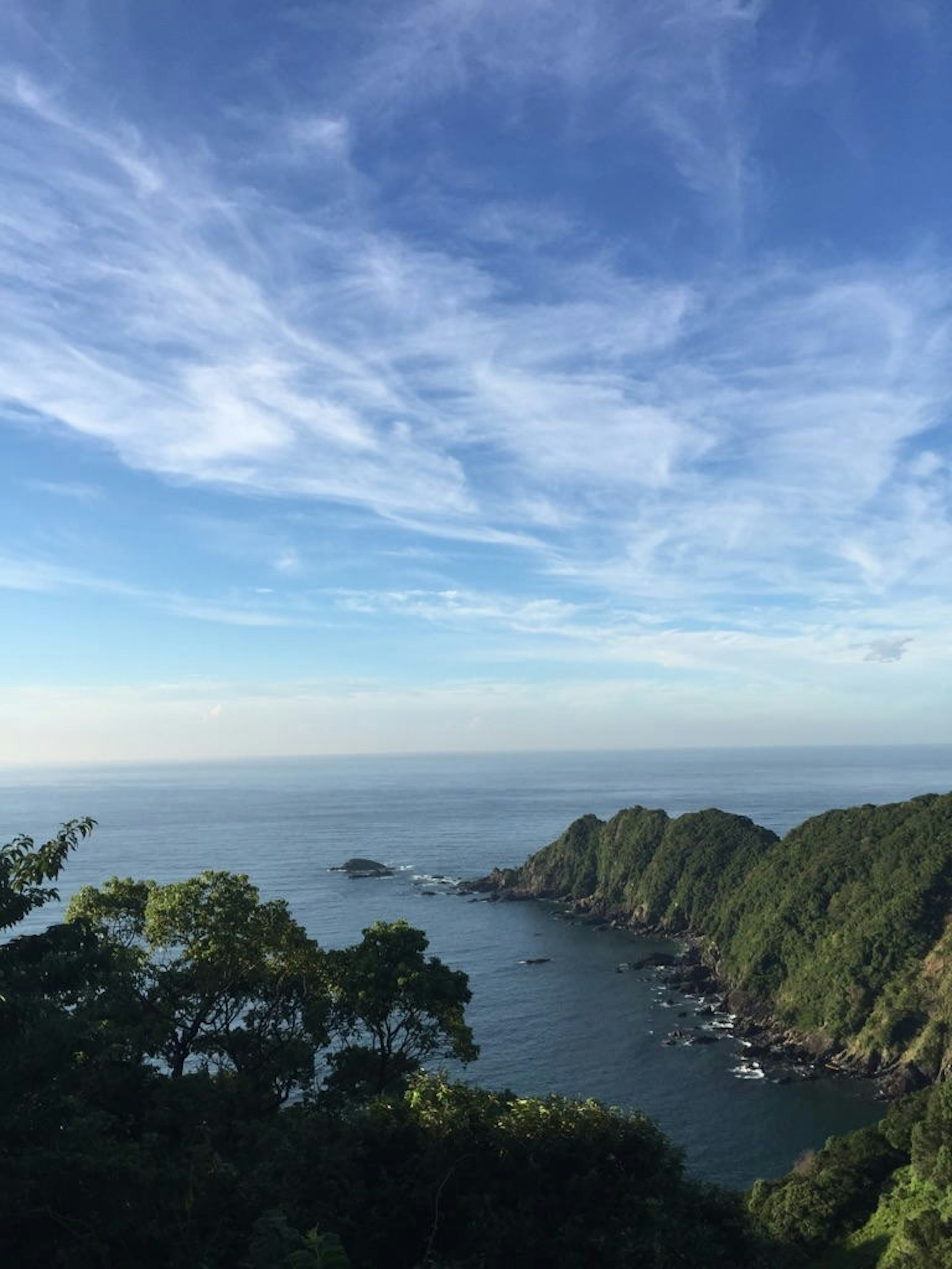 Scenic coastline with blue sky lush green hills and calm sea