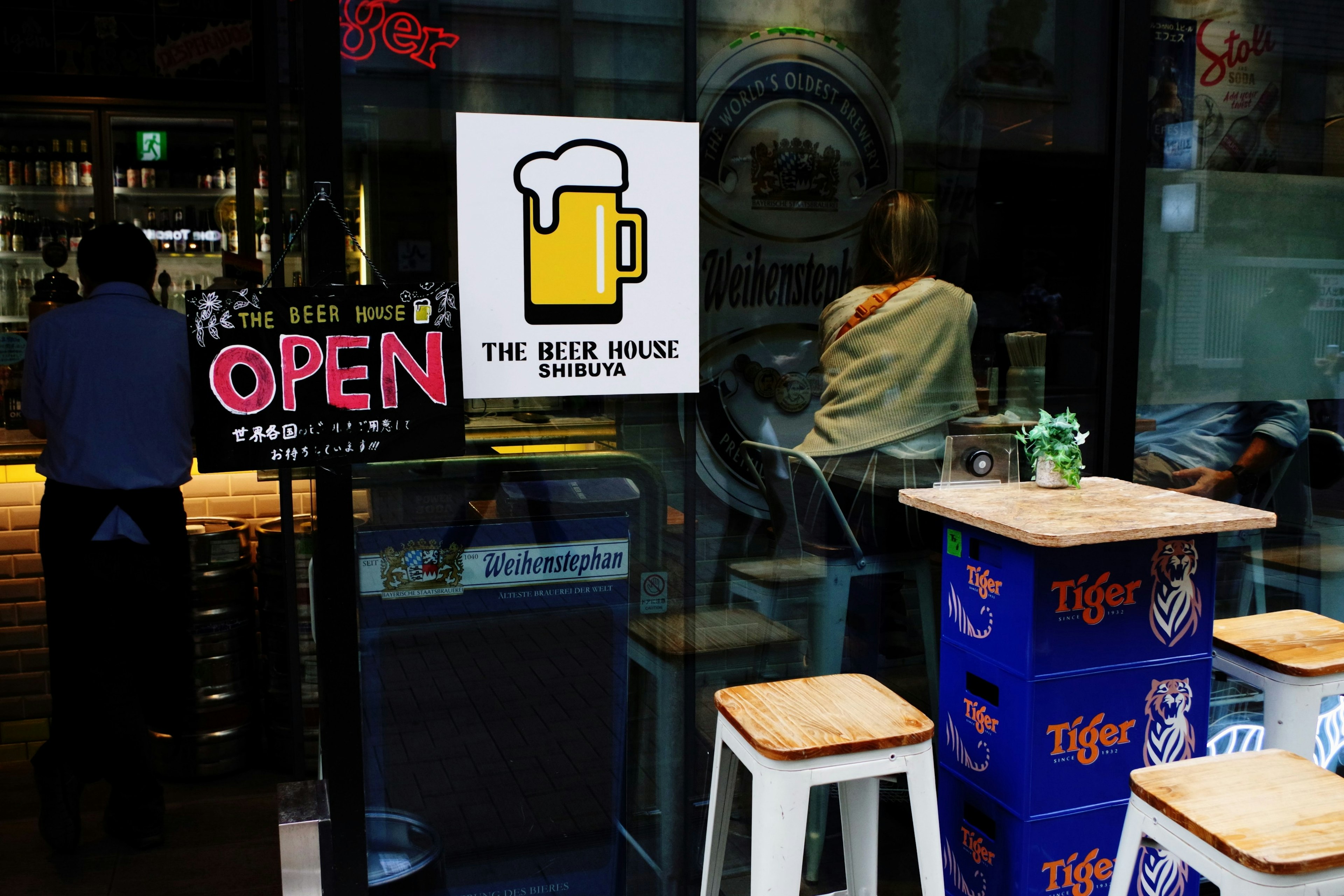 Exterior de The Beer House con un letrero abierto y un ícono de cerveza