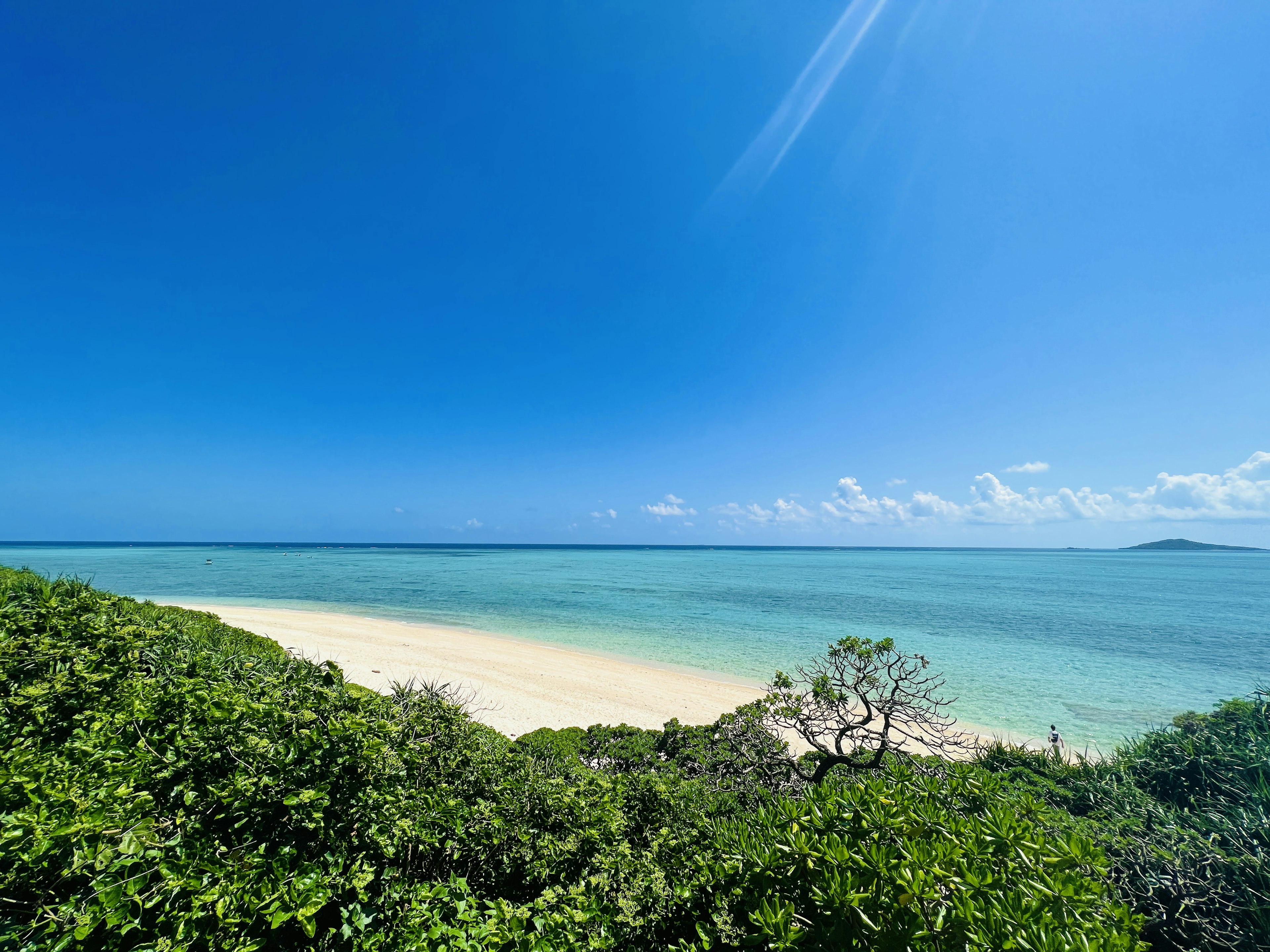 ทิวทัศน์ชายหาดที่สวยงามพร้อมทะเลสีน้ำเงินและทรายขาว