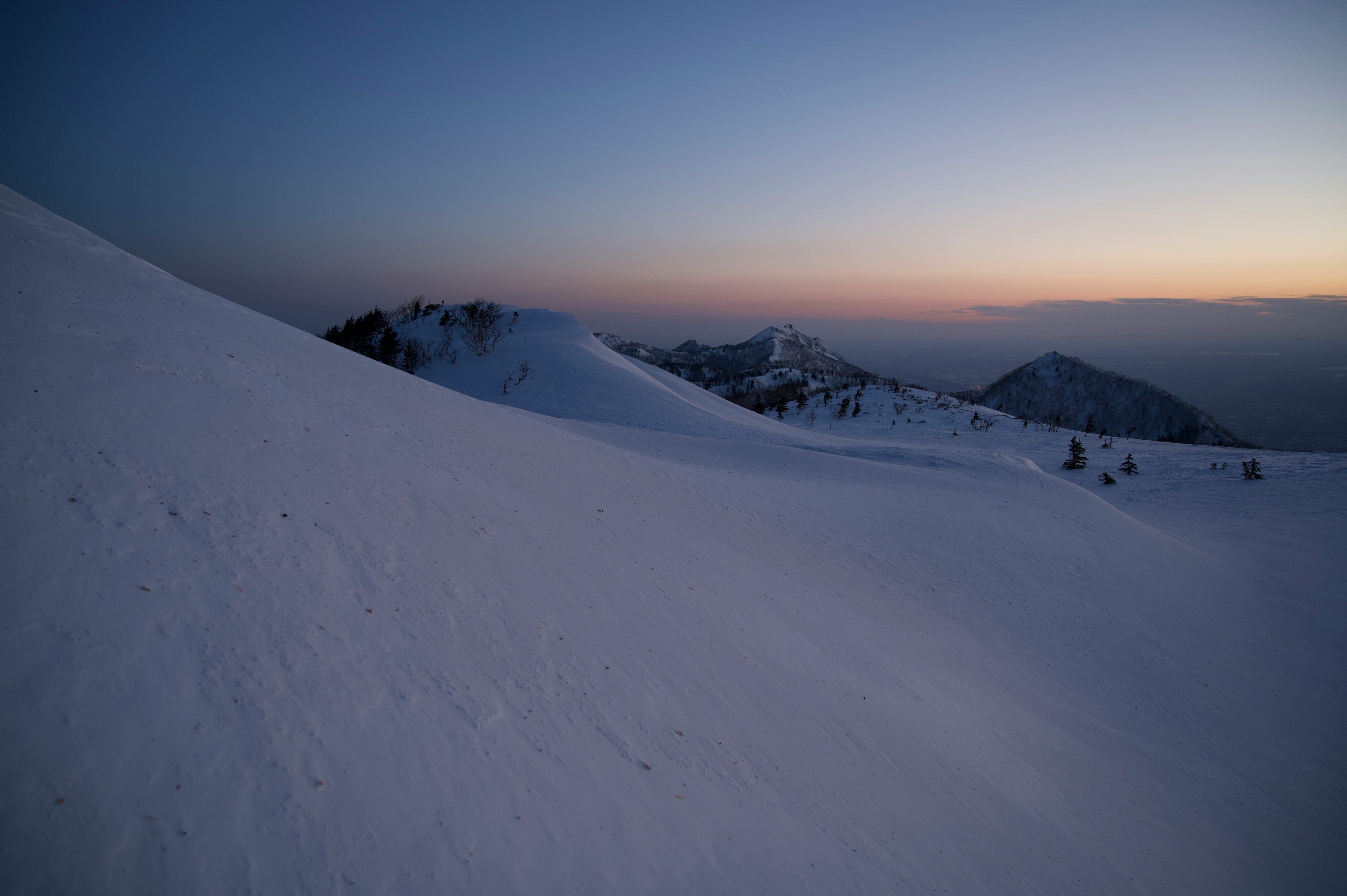 雪に覆われた山の風景と薄明かり