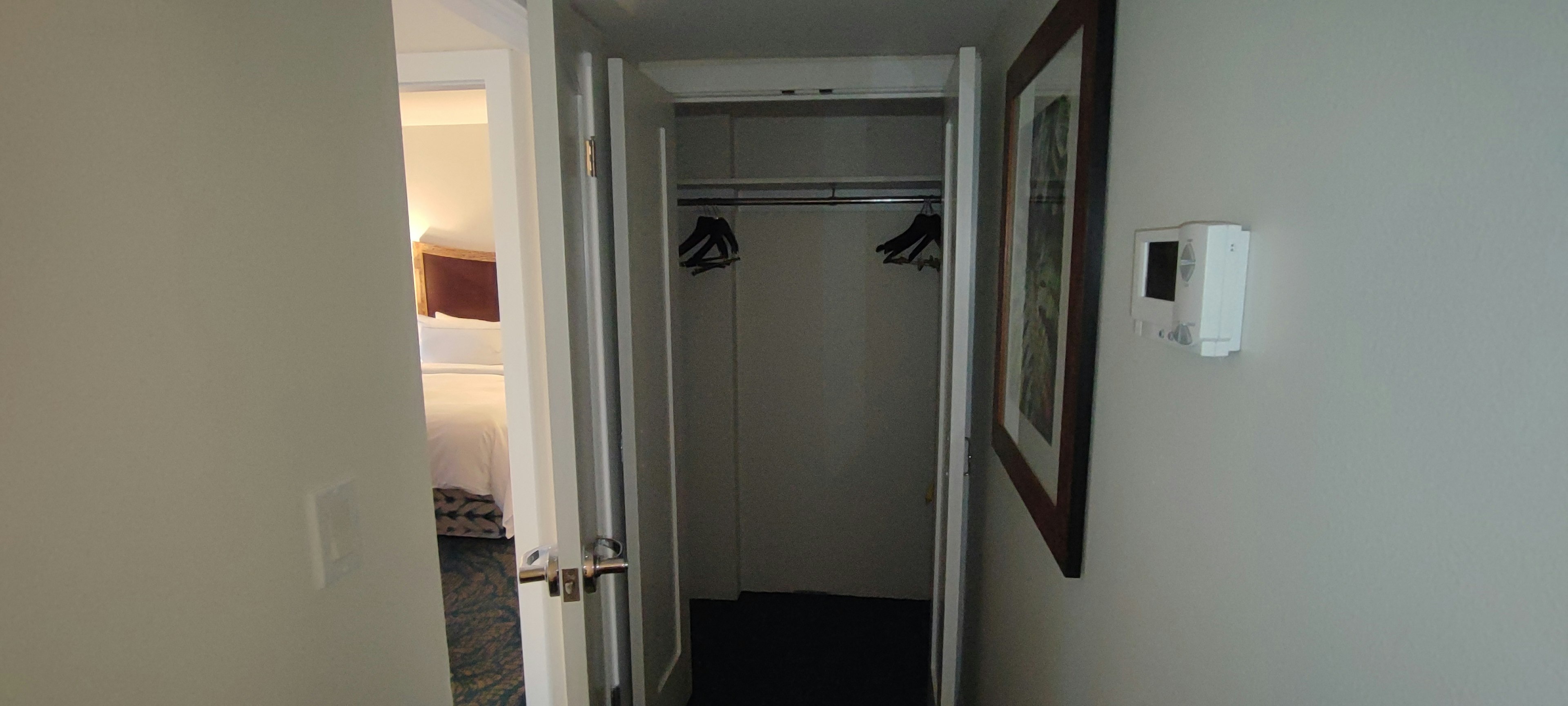 Entrance to a hotel room showing a closet with hangers