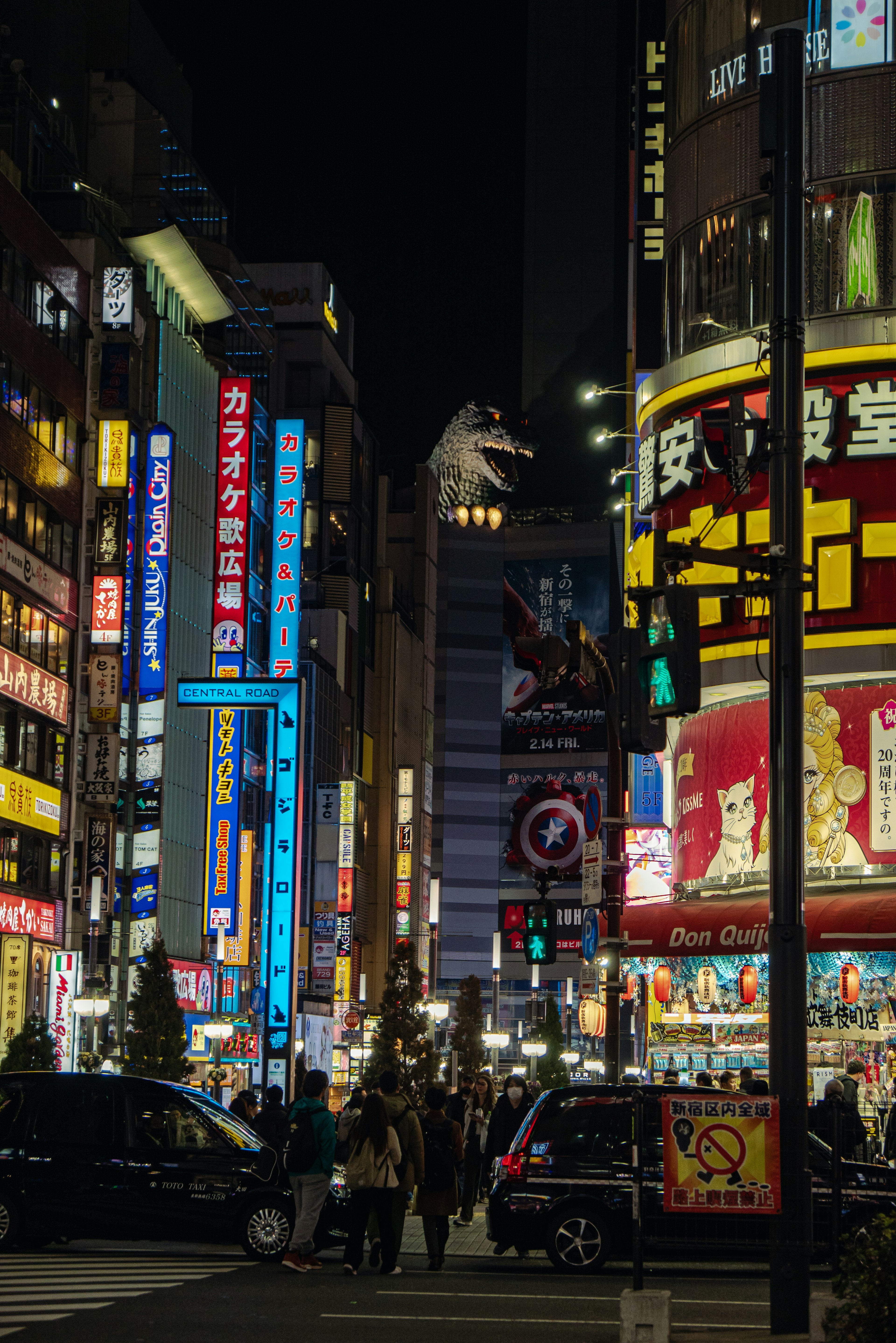 Scène nocturne de Shinjuku avec des enseignes au néon vibrantes et une figure de Godzilla