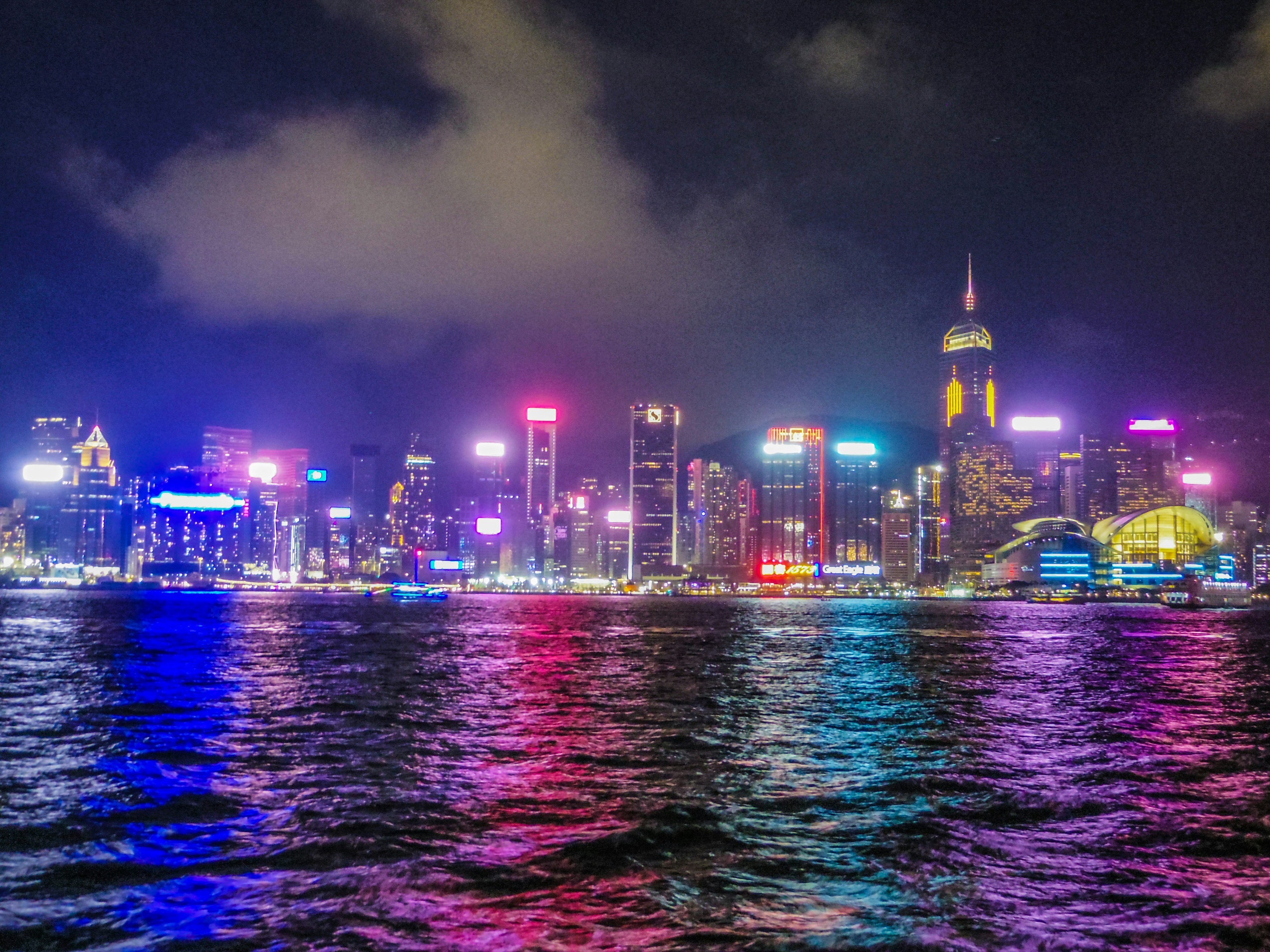 Vibrant skyline of Hong Kong at night with colorful lights reflecting on the water