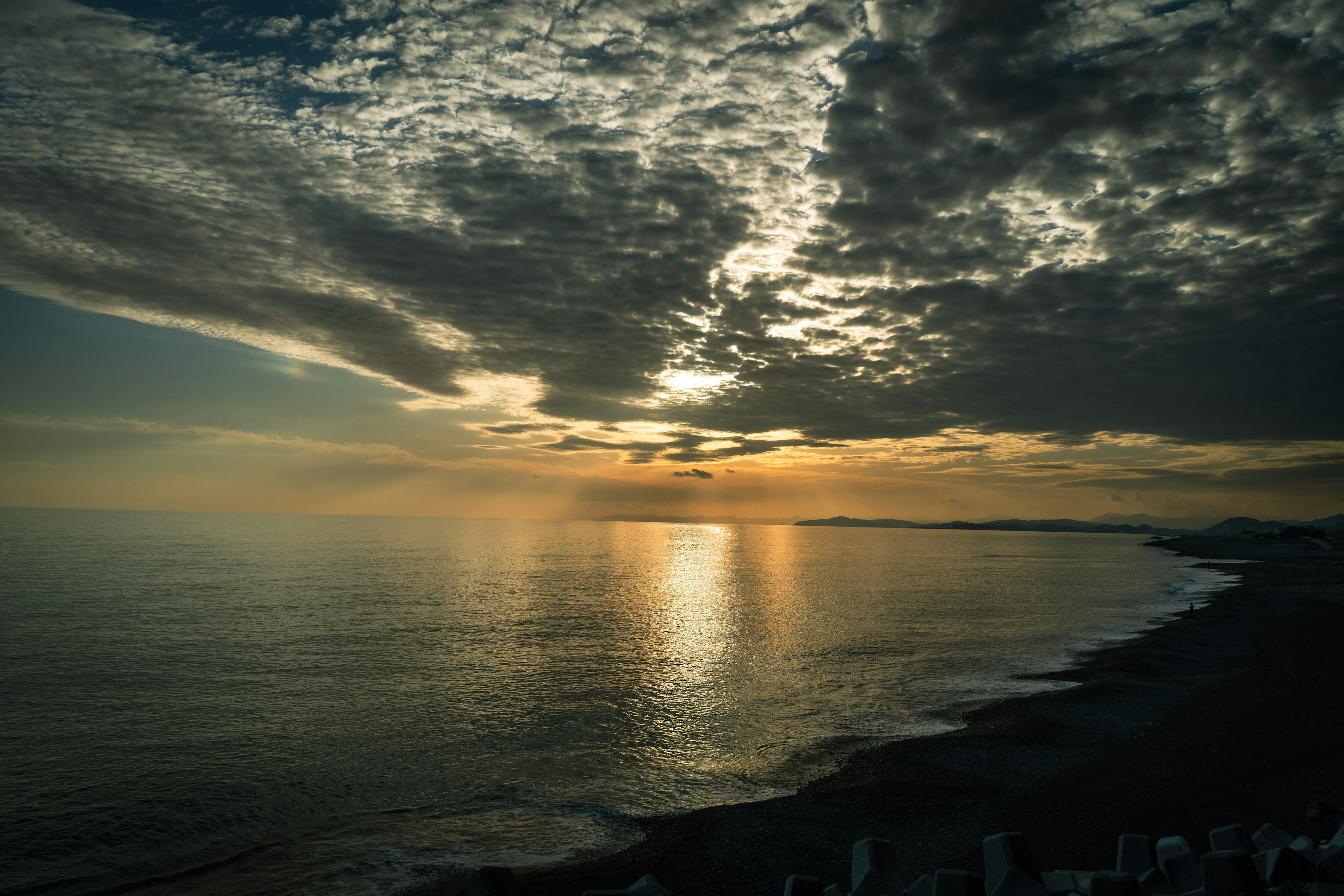 Paysage magnifique avec le coucher de soleil se reflétant sur l'océan nuages dramatiques et vagues douces