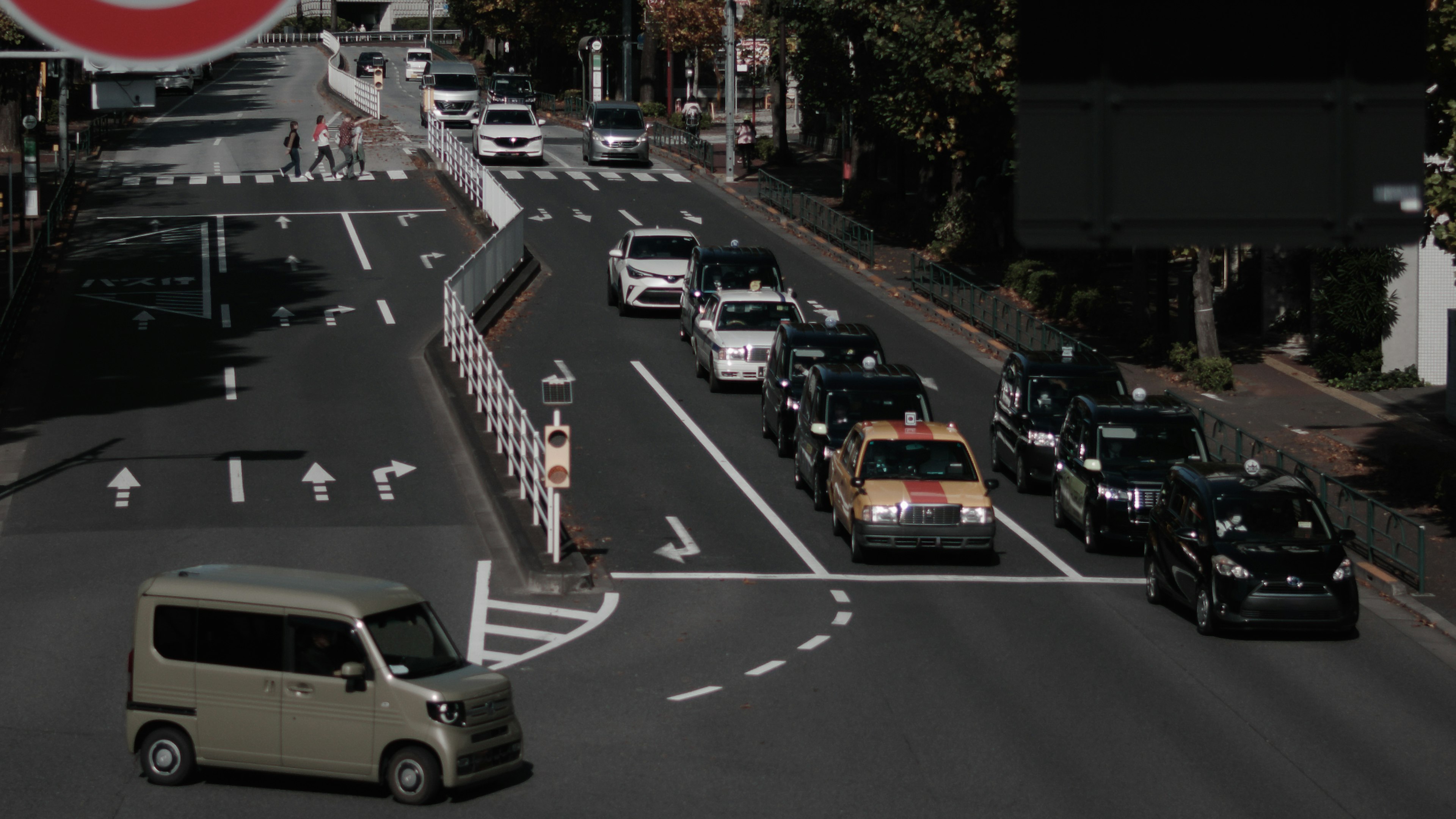 交通信号のある都市の交差点に車が並ぶ風景