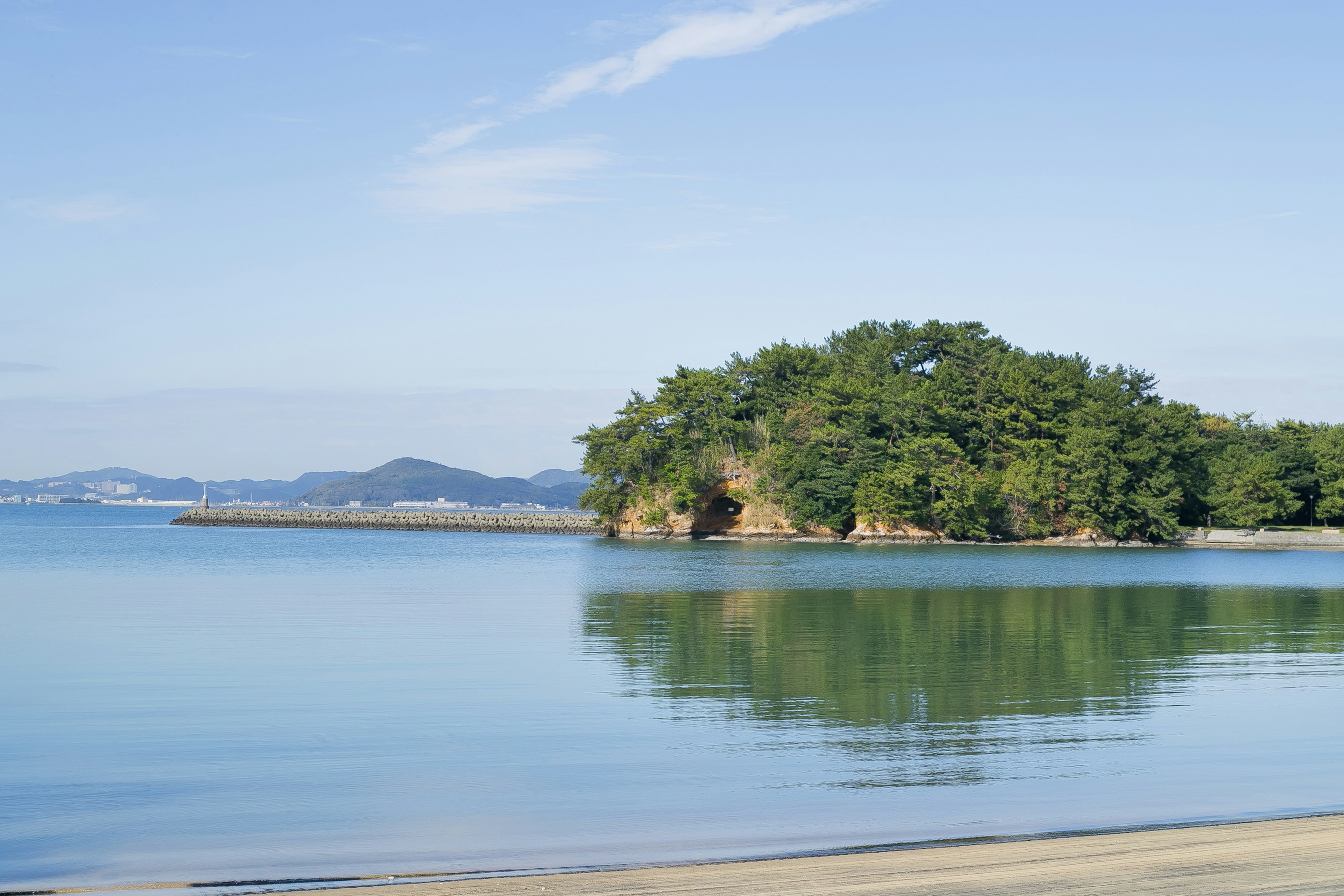 Pemandangan laut tenang dengan pulau hijau subur