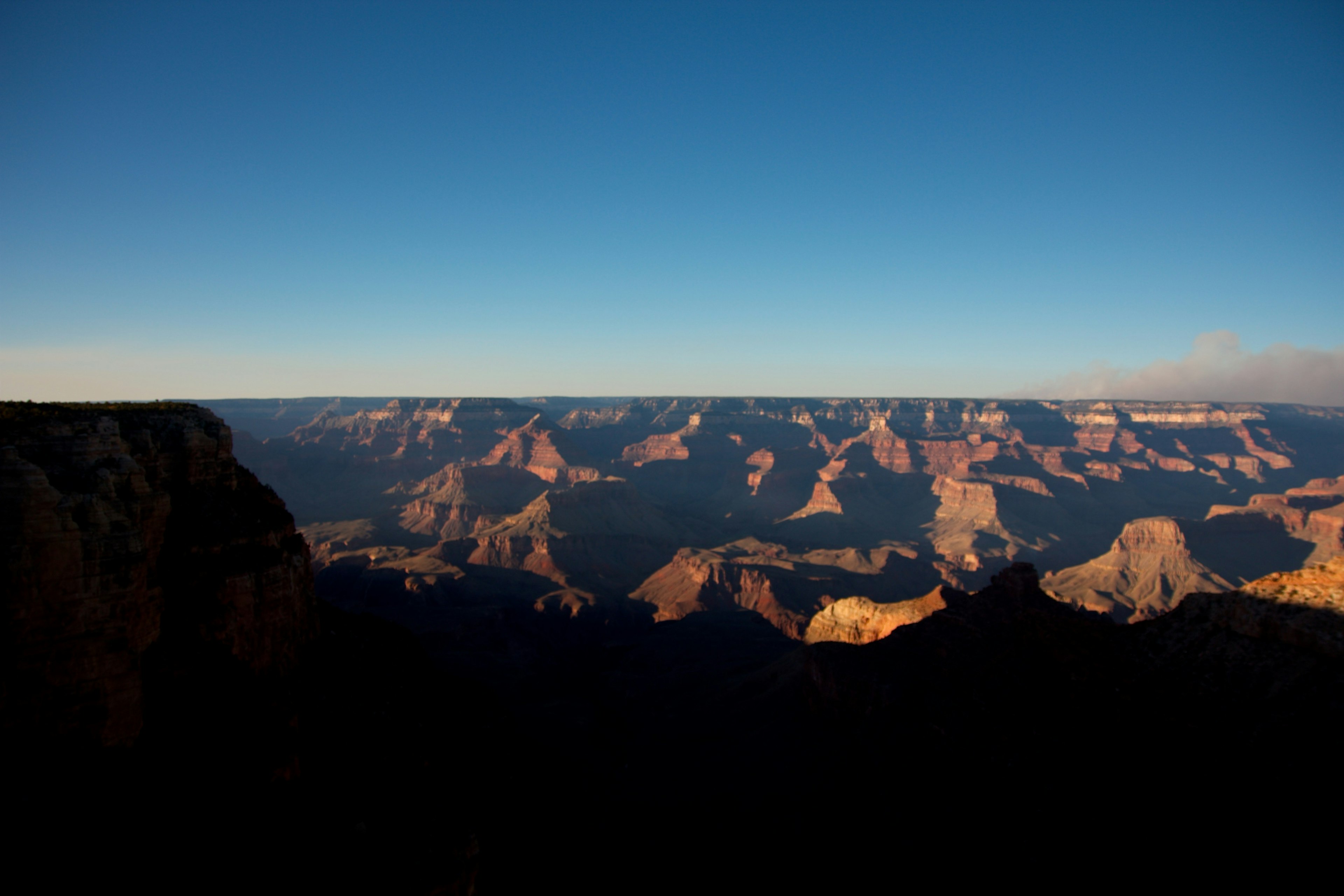 Ampia vista del Grand Canyon con cielo blu e silhouette montane