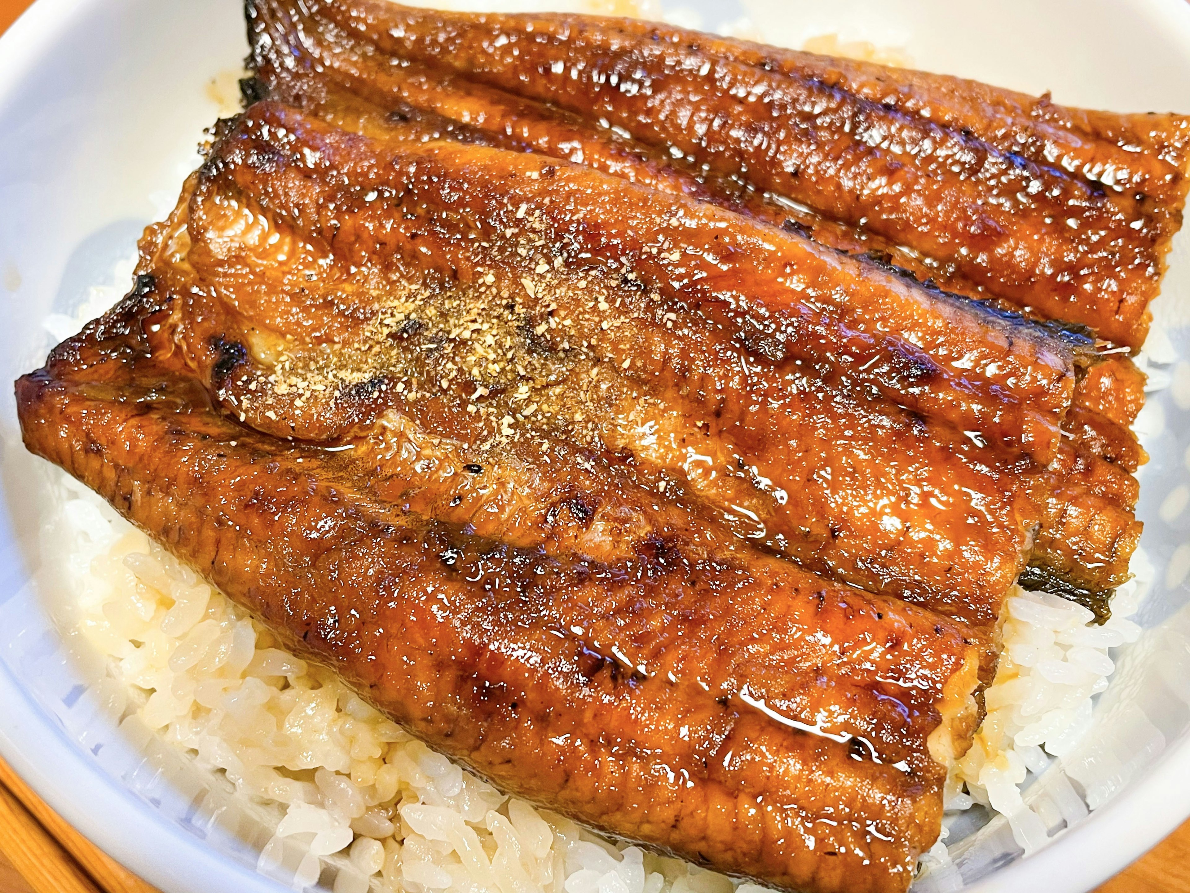 Anguille grillée servie sur un lit de riz blanc