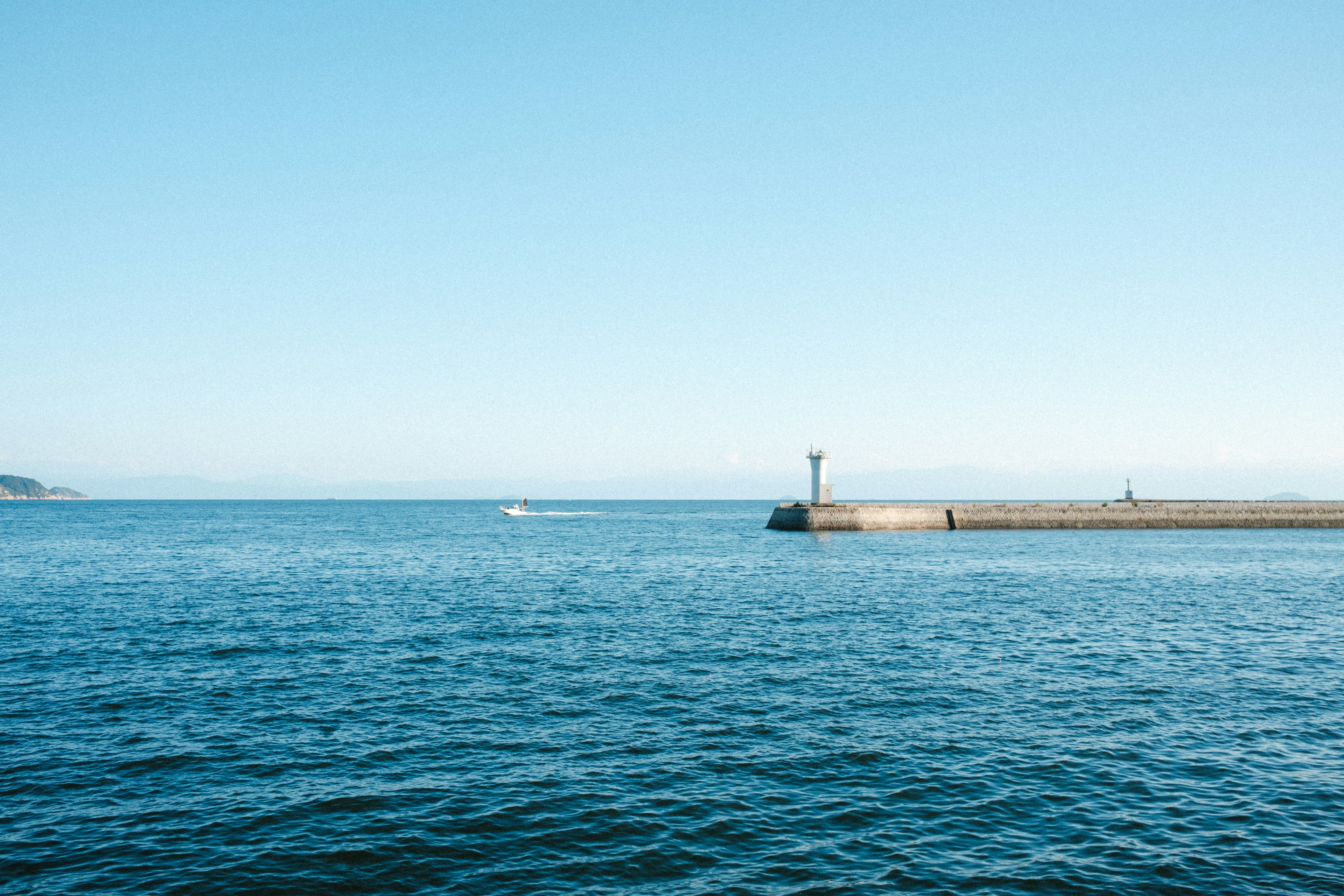 Vista escénica del océano azul y el cielo con un muelle