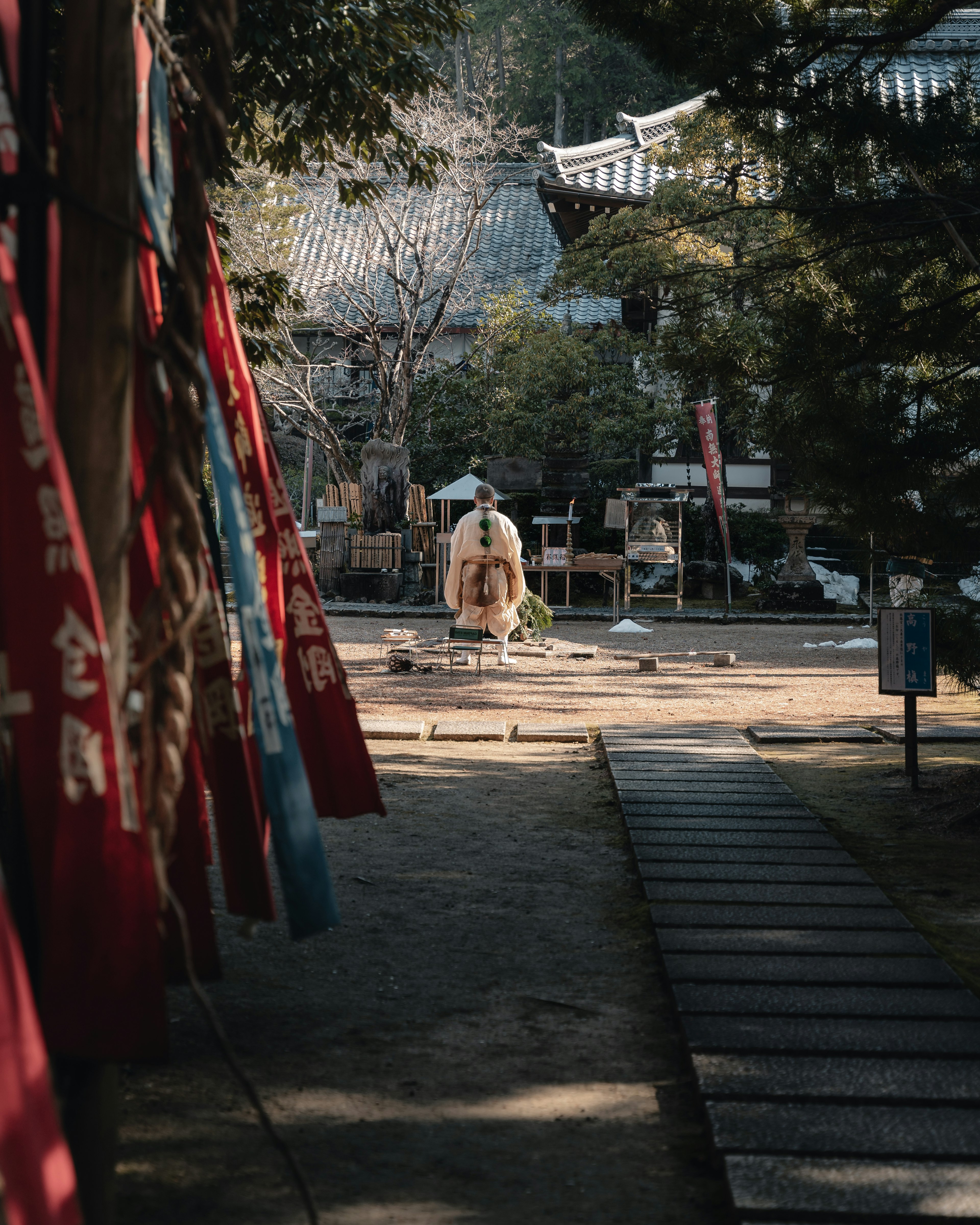 Stone statue in a serene garden with red flags